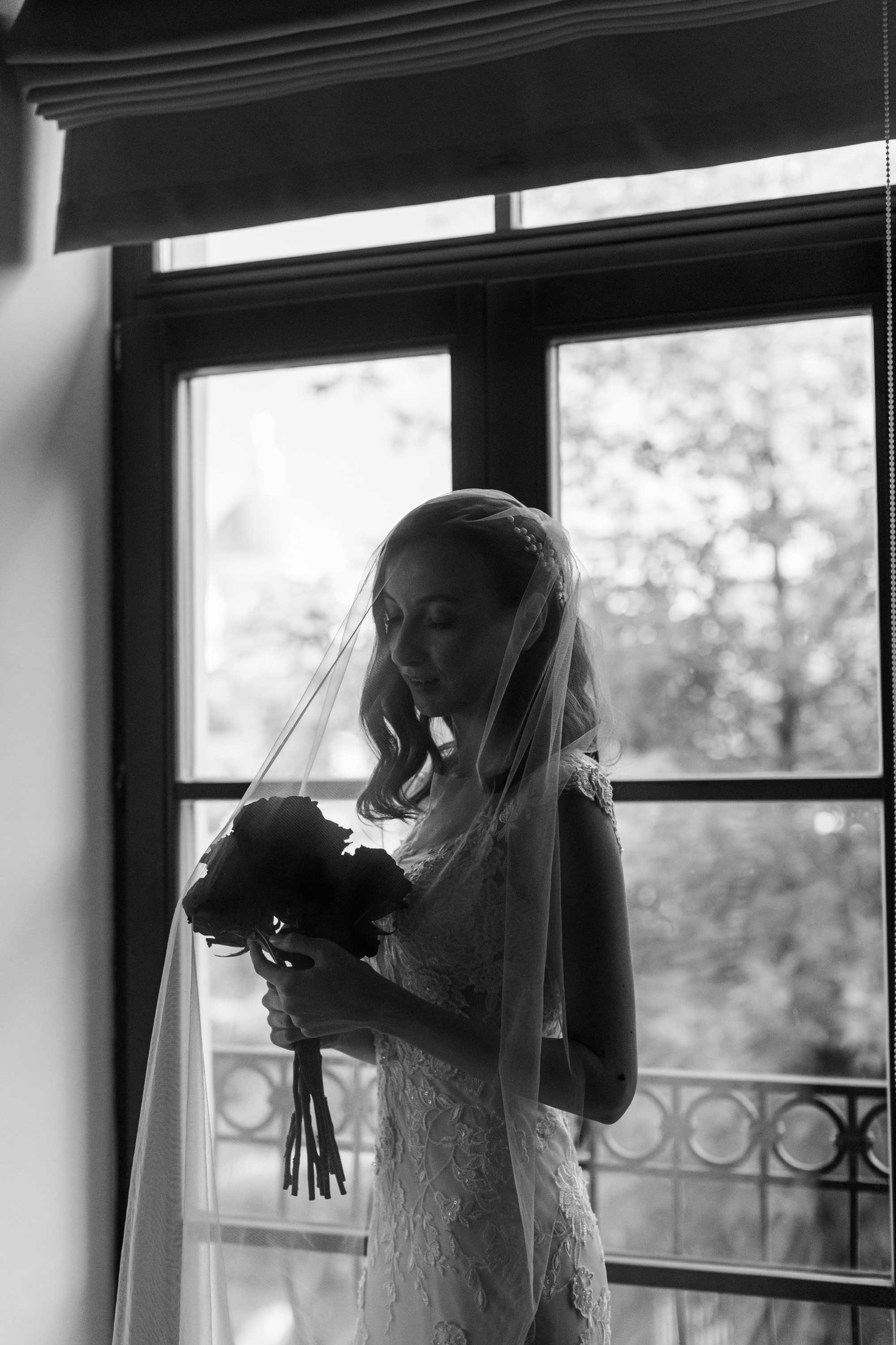 Невеста стоит, накинув фату а лицо
