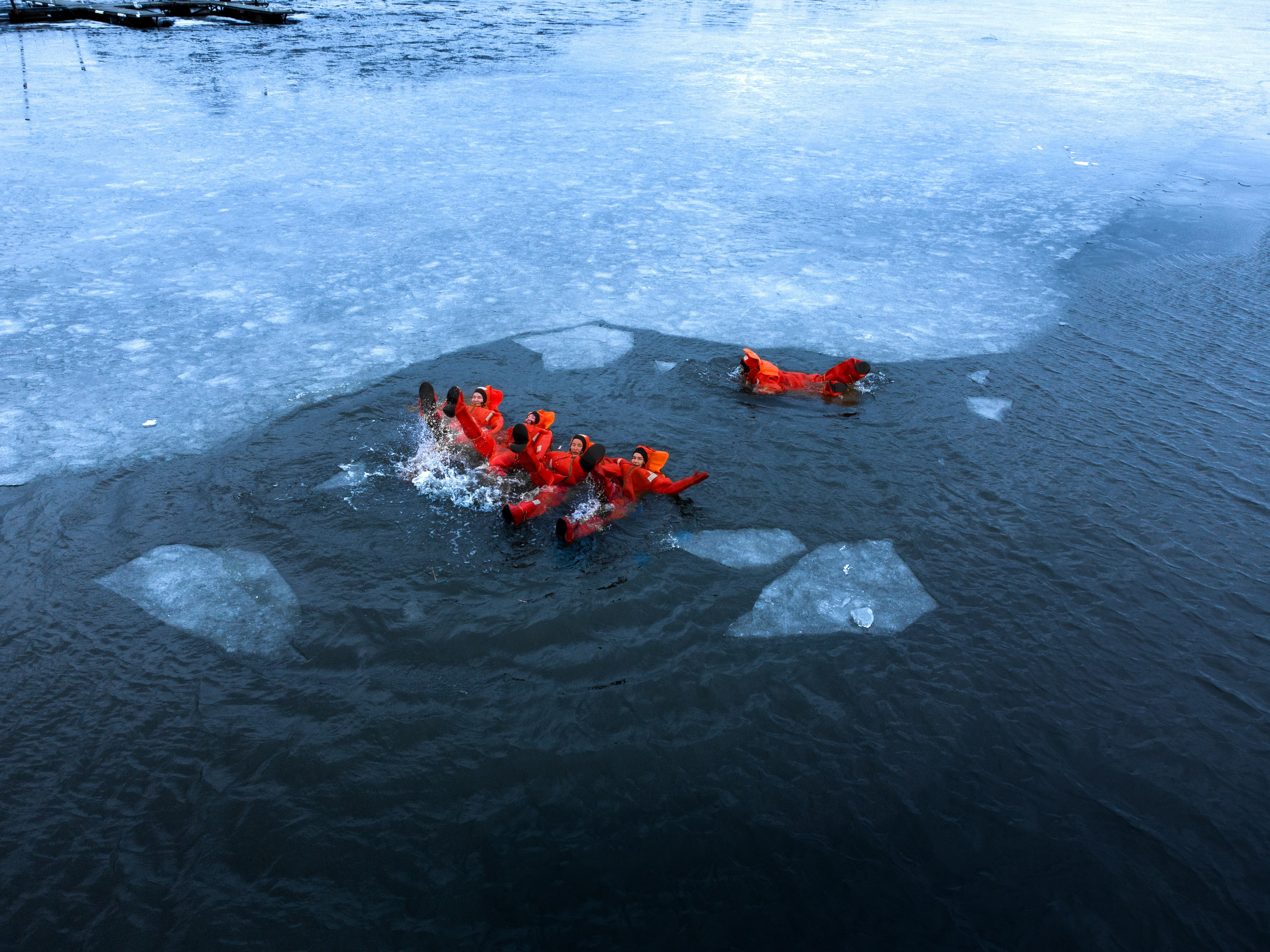 Люди купаются среди льдин, в спасательных оранжевых термо костюмах, айс флоатинг Ярославль