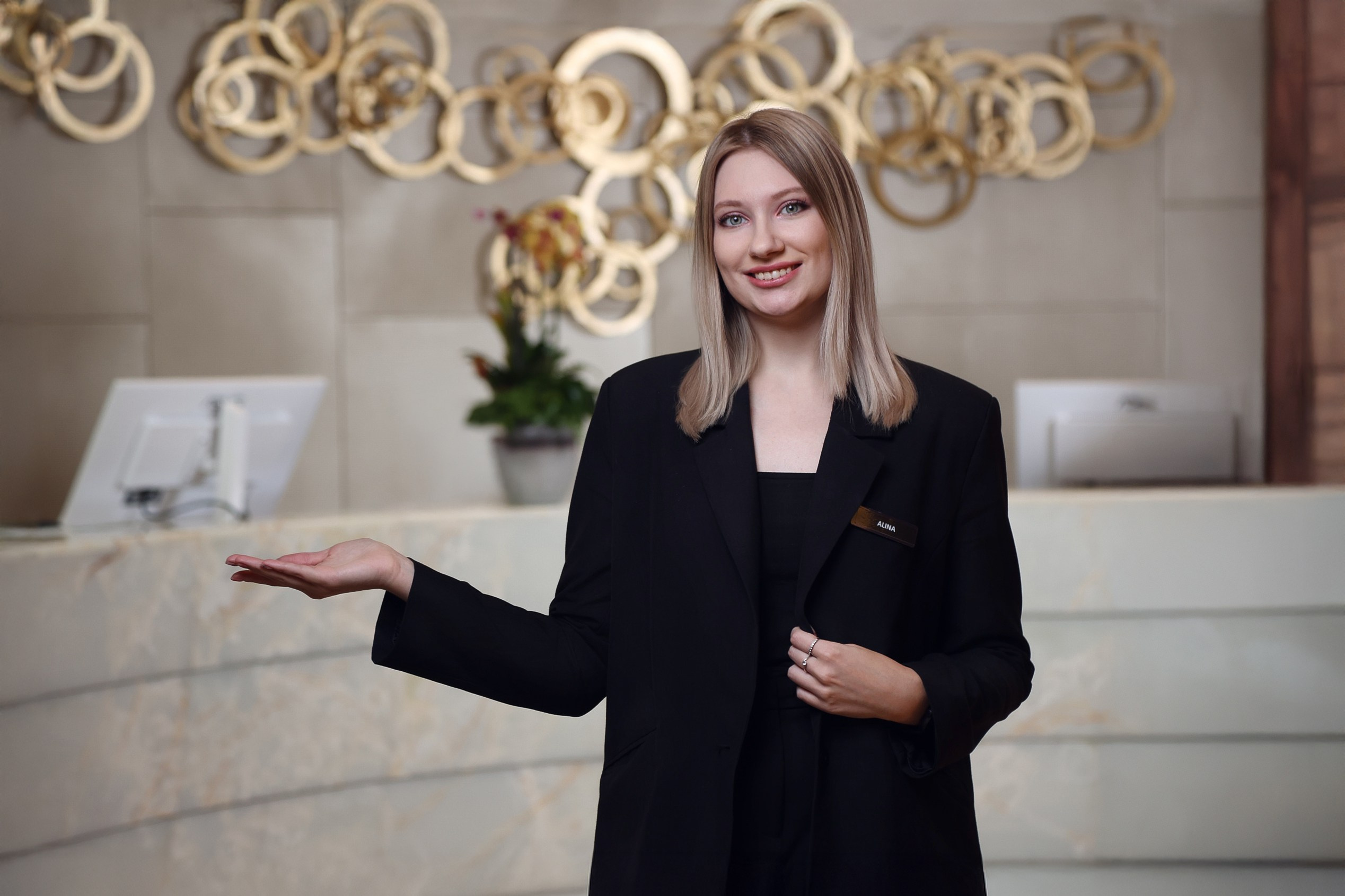 Администратор на ресепшене пятизвездочного отеля в Москве приветственно улыбается гостю. Фотограф Василий Жуков.