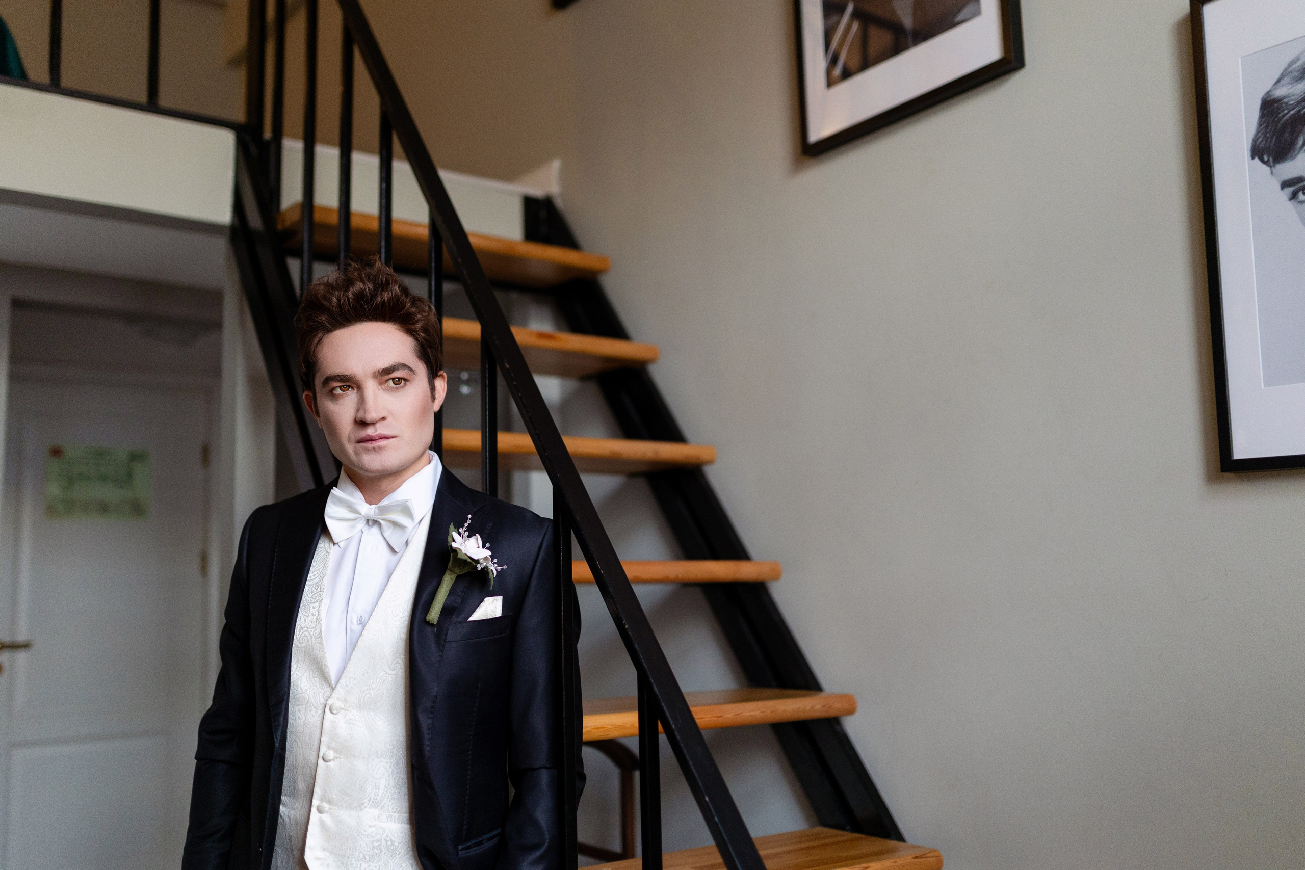 К лестнице в черном костюме подошел жених.
