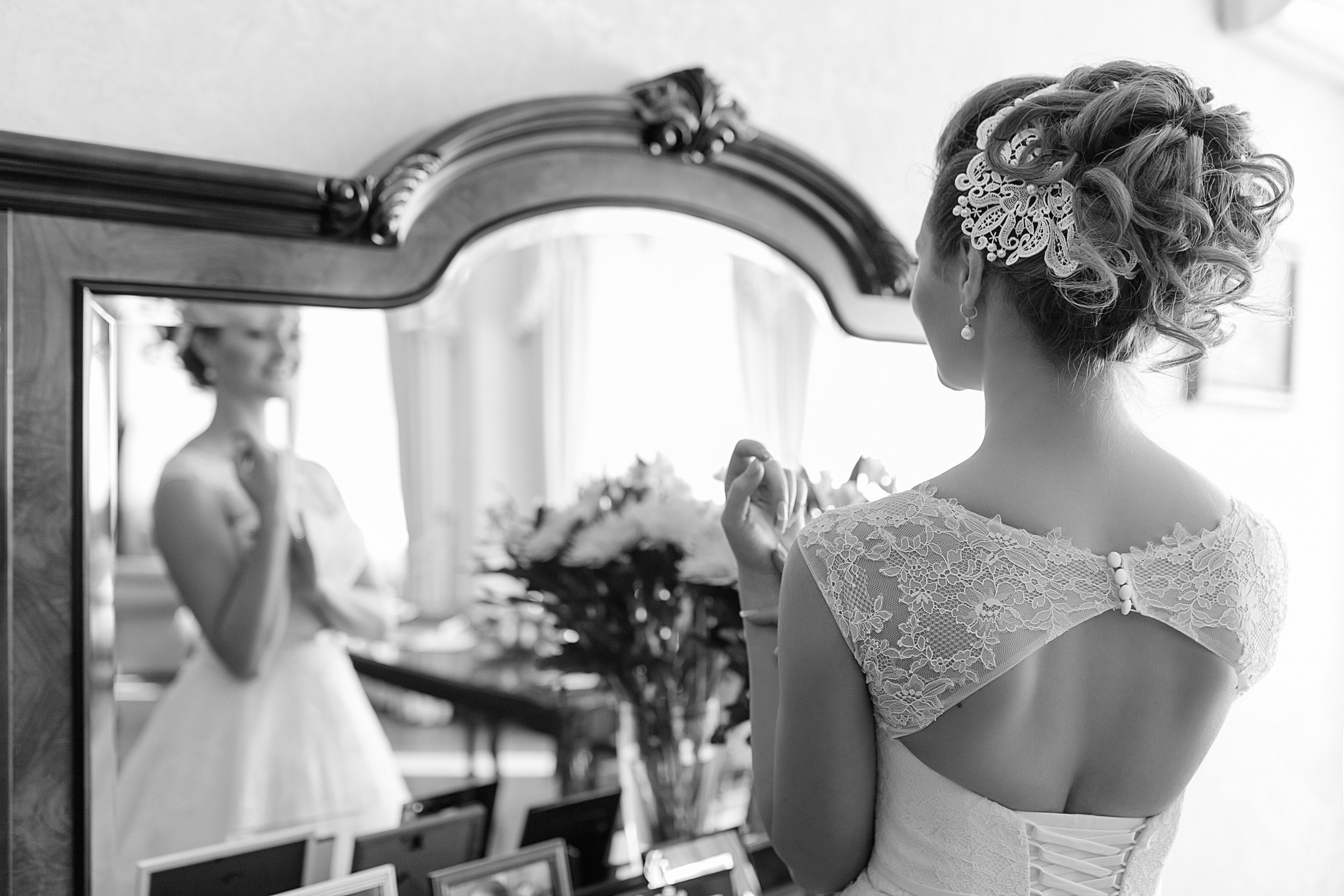 Невеста смотрит на свое отражение в зеркале