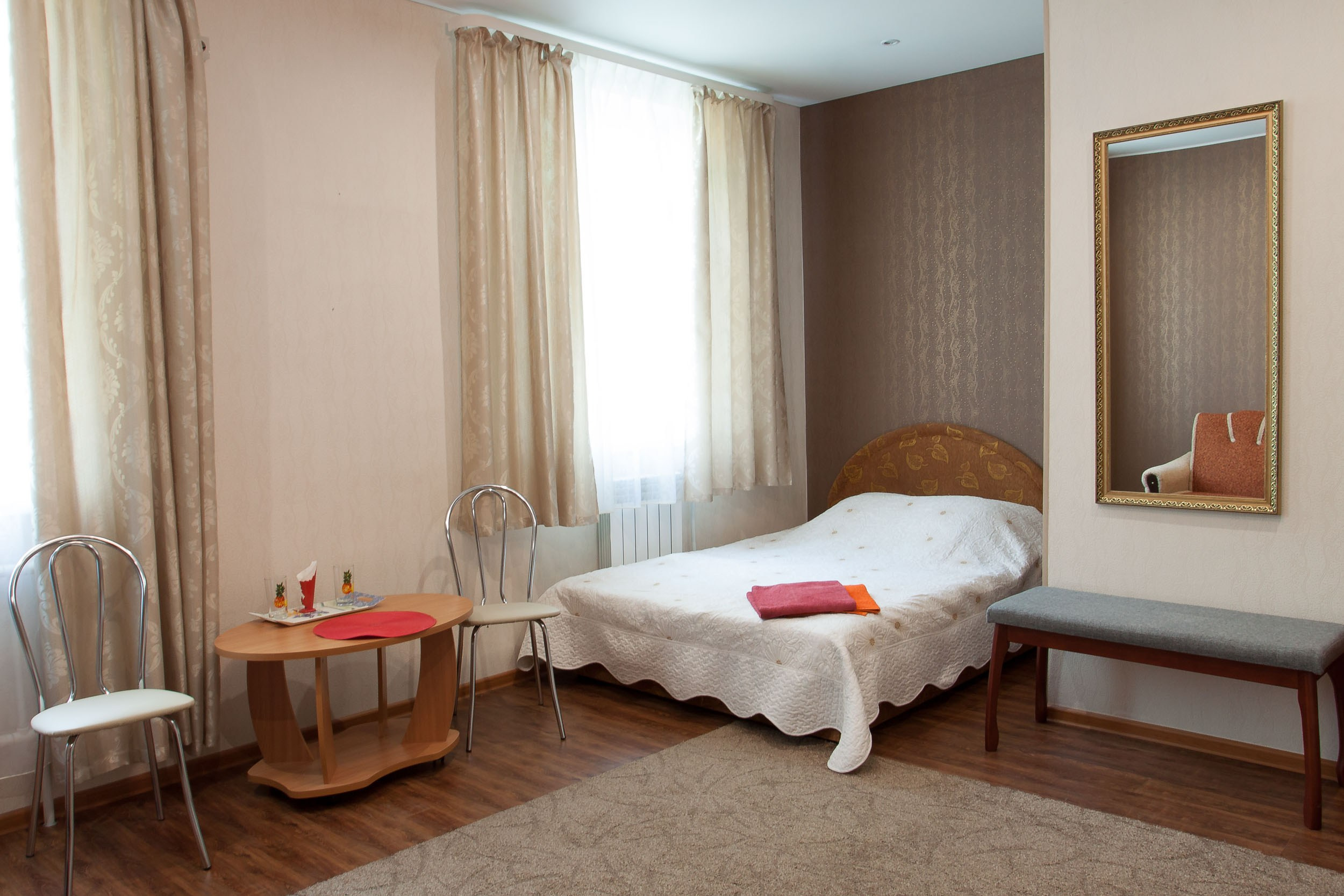 Интерьер гостевого дома Горница, комната с большим окном и светлыми шторами.