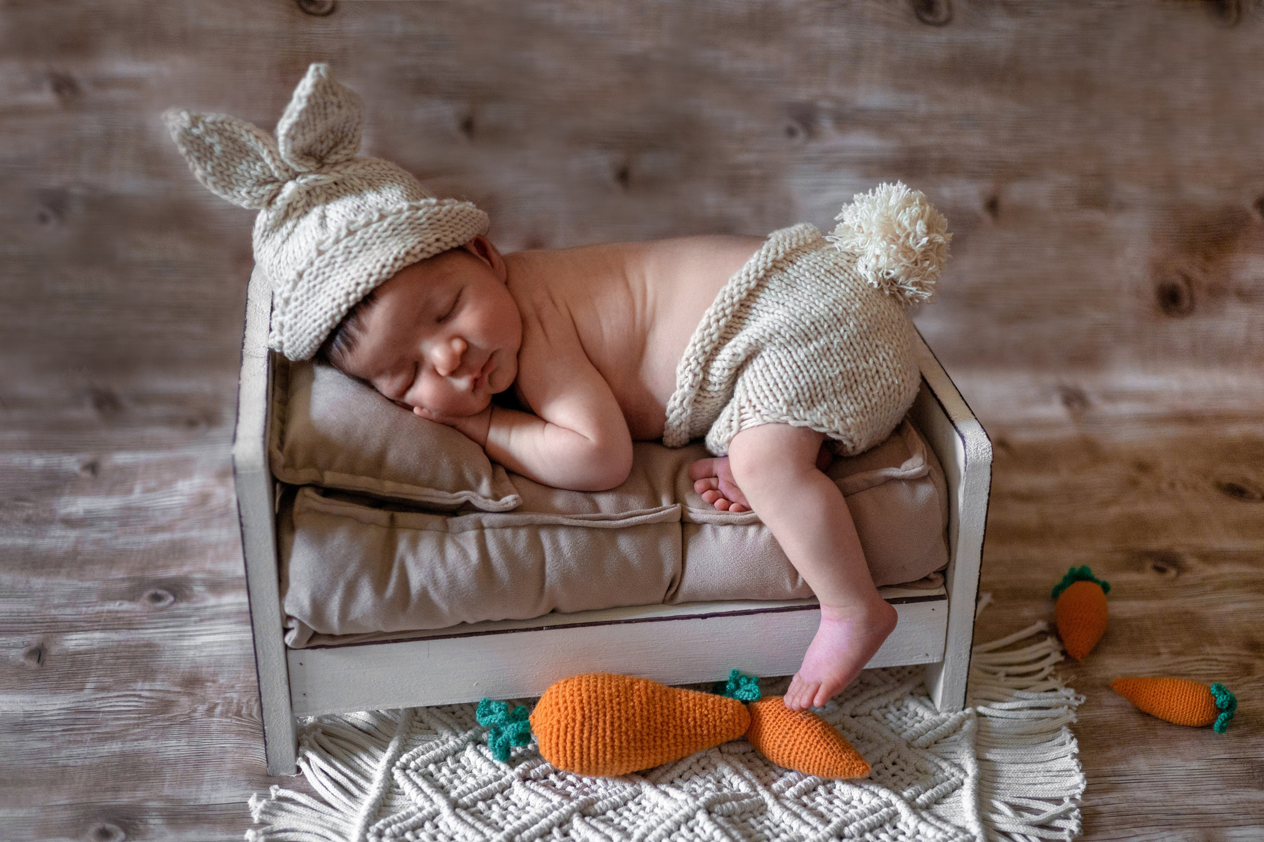 новорожденный ребенок фотосессия в саратове, в костюме зайчика с морковками на кроватке, заячий хвостик