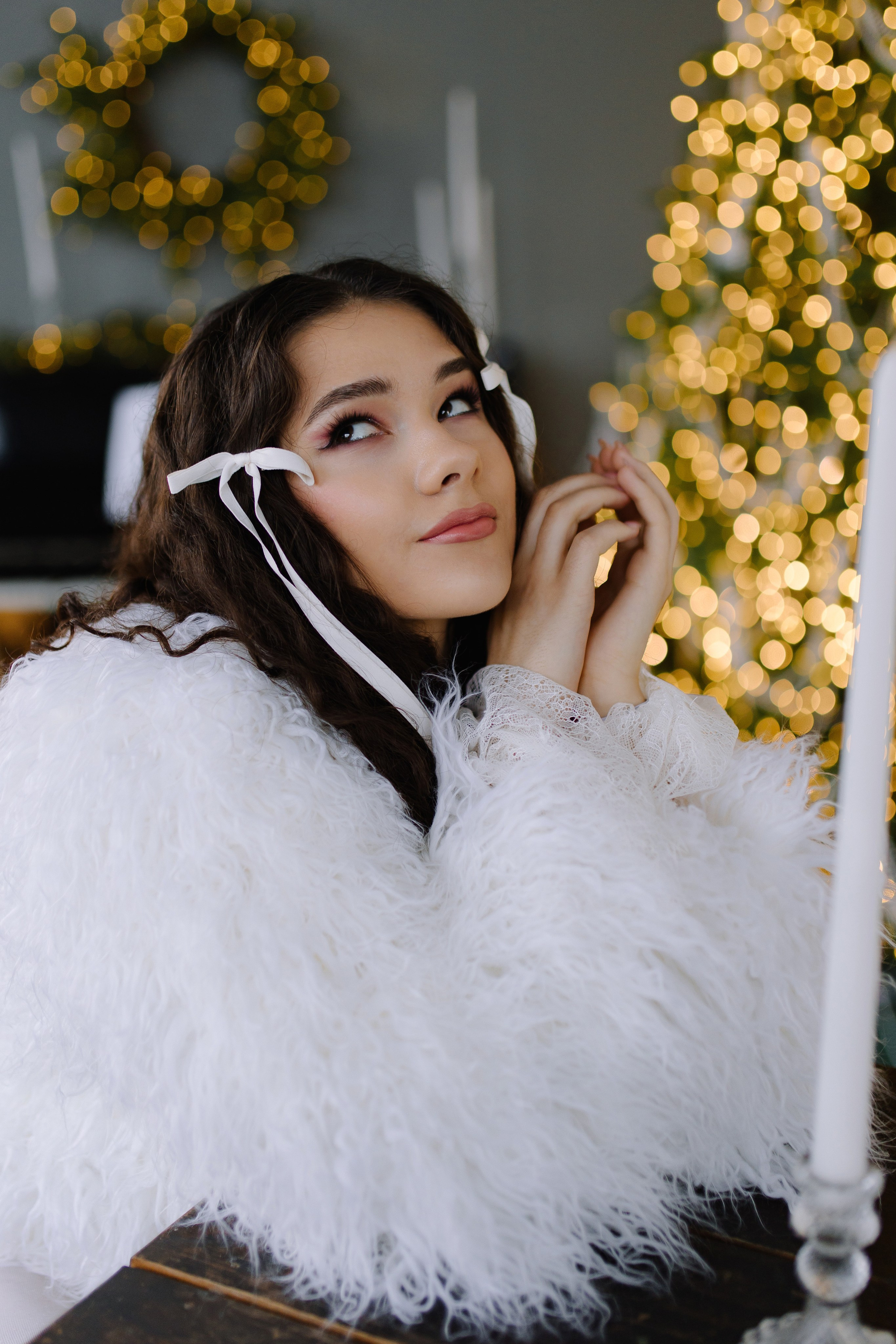 Девушка в праздничном платье и сияющих украшениях улыбается перед камерой в фотостудии.