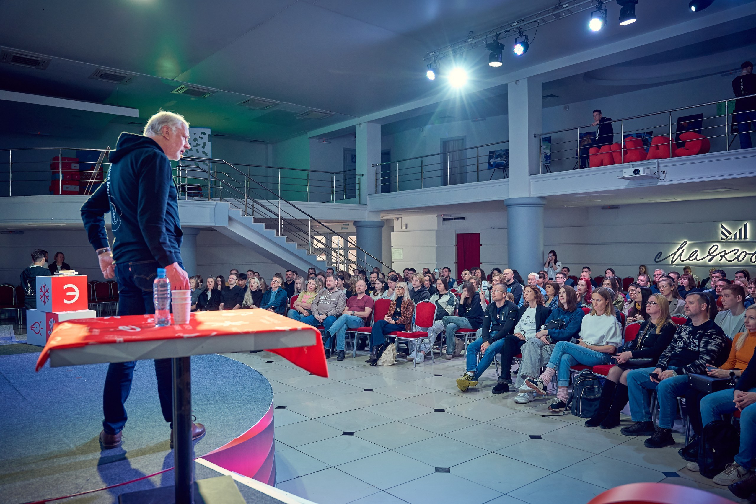 репортажный снимок спикера и аудитории со стороны сцены