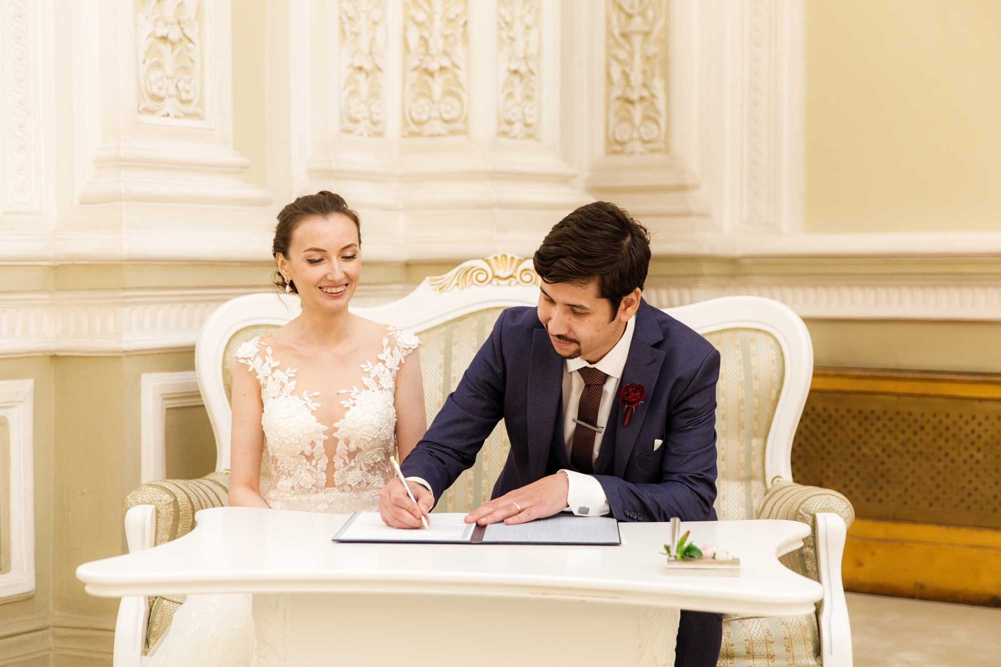 Невеста и жених ставят подписи