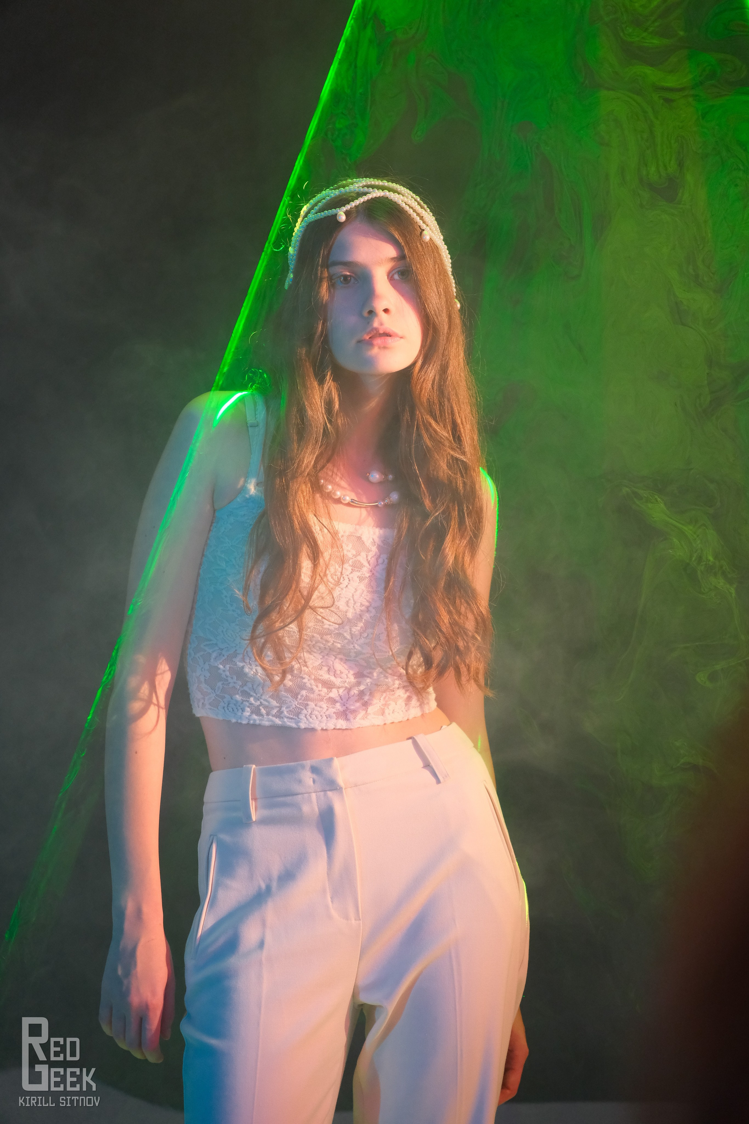 Студийный портрет девушки в лазерной подсветке с задумчивым взглядом.