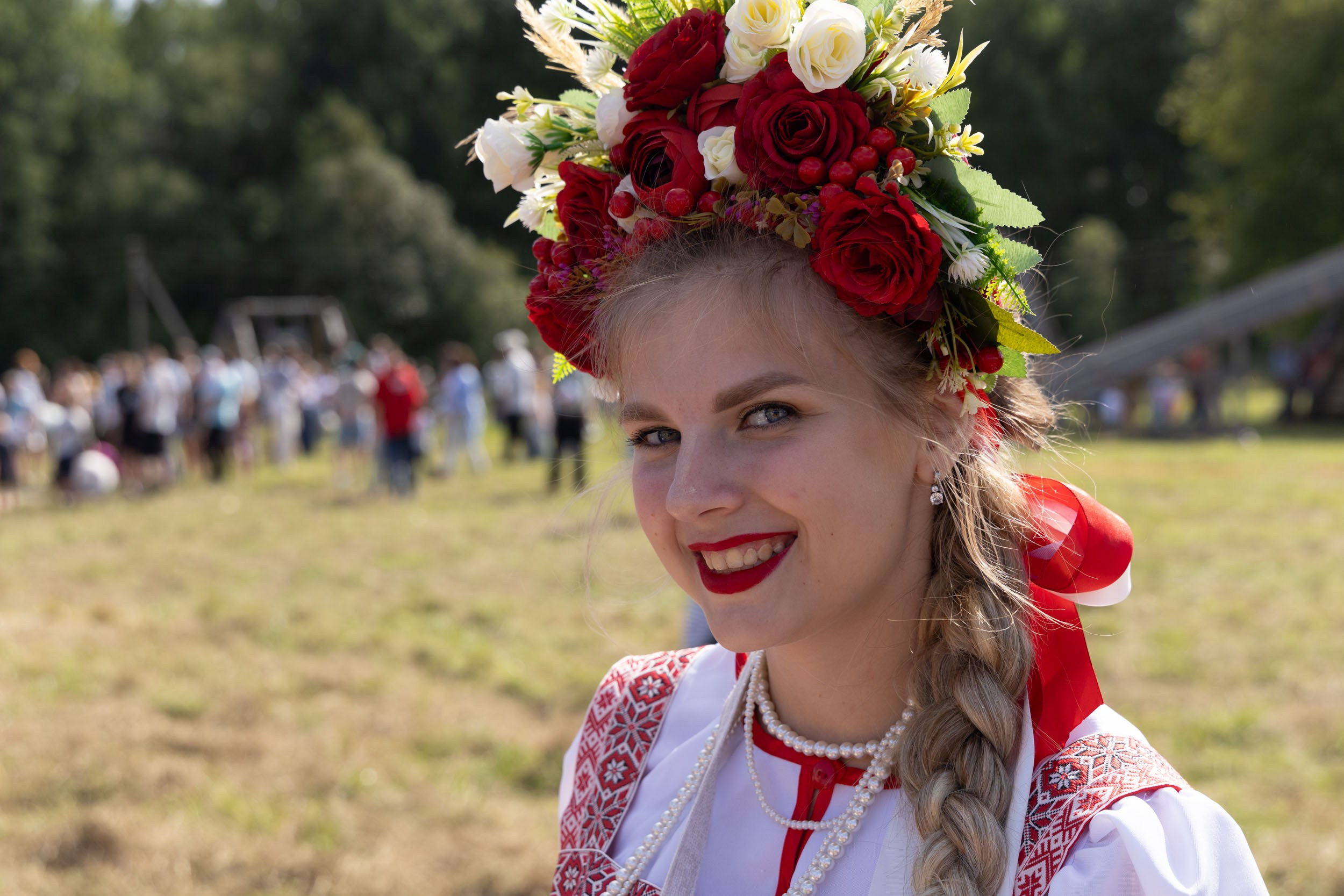 Девушка в русской одежде с венком на голове.