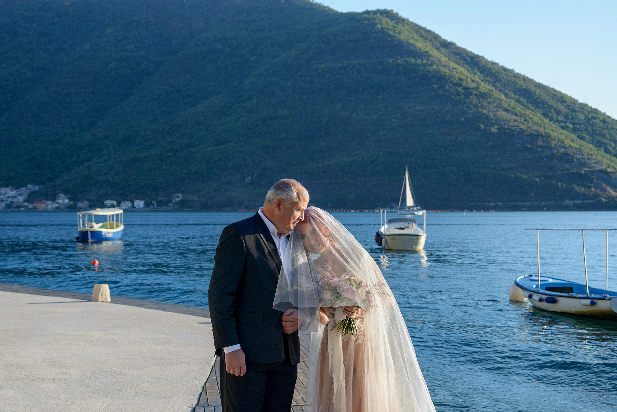 Отец невесты ведет дочь на свадебную церемонию