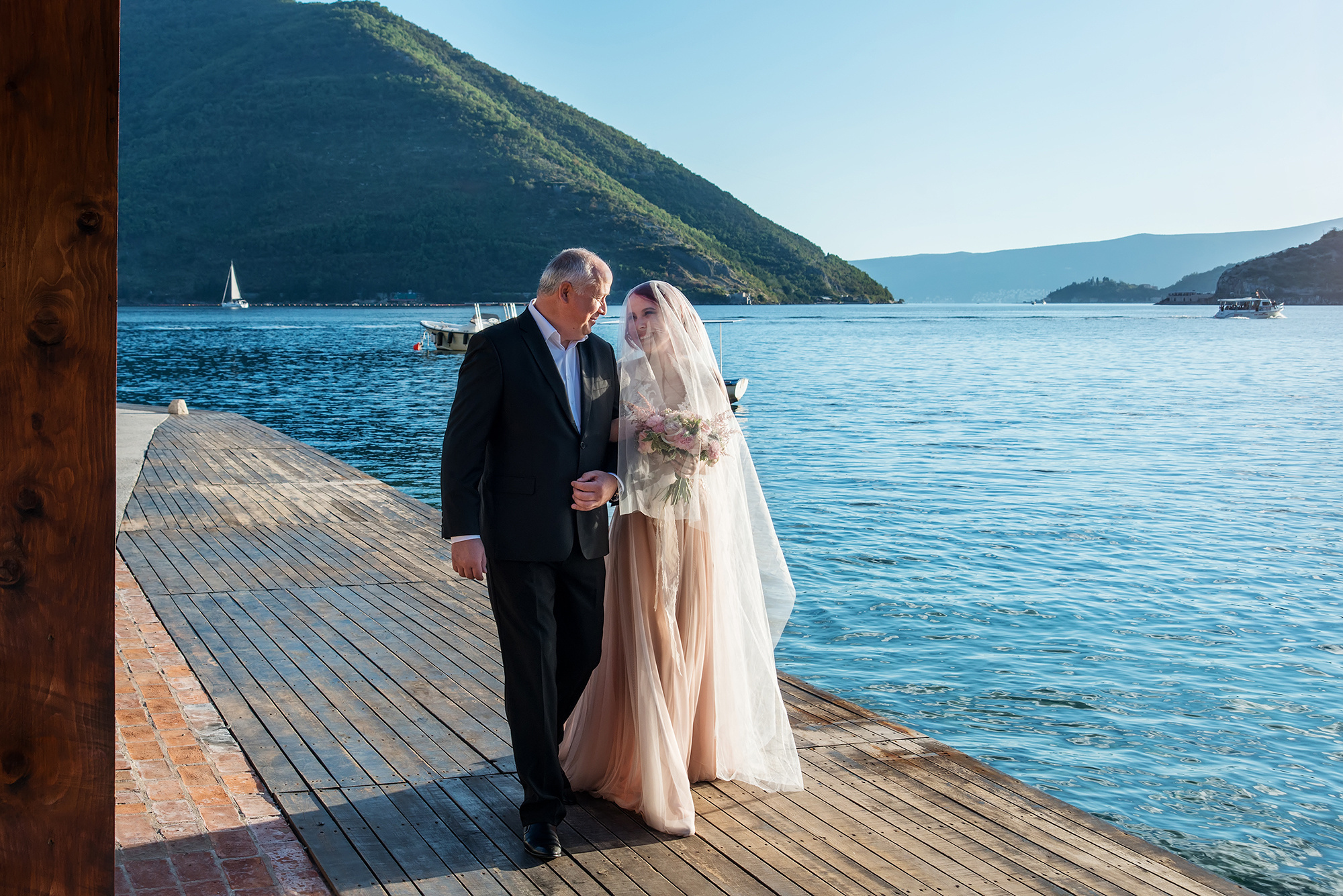 Отец невесты ведет дочь на свадебную церемонию