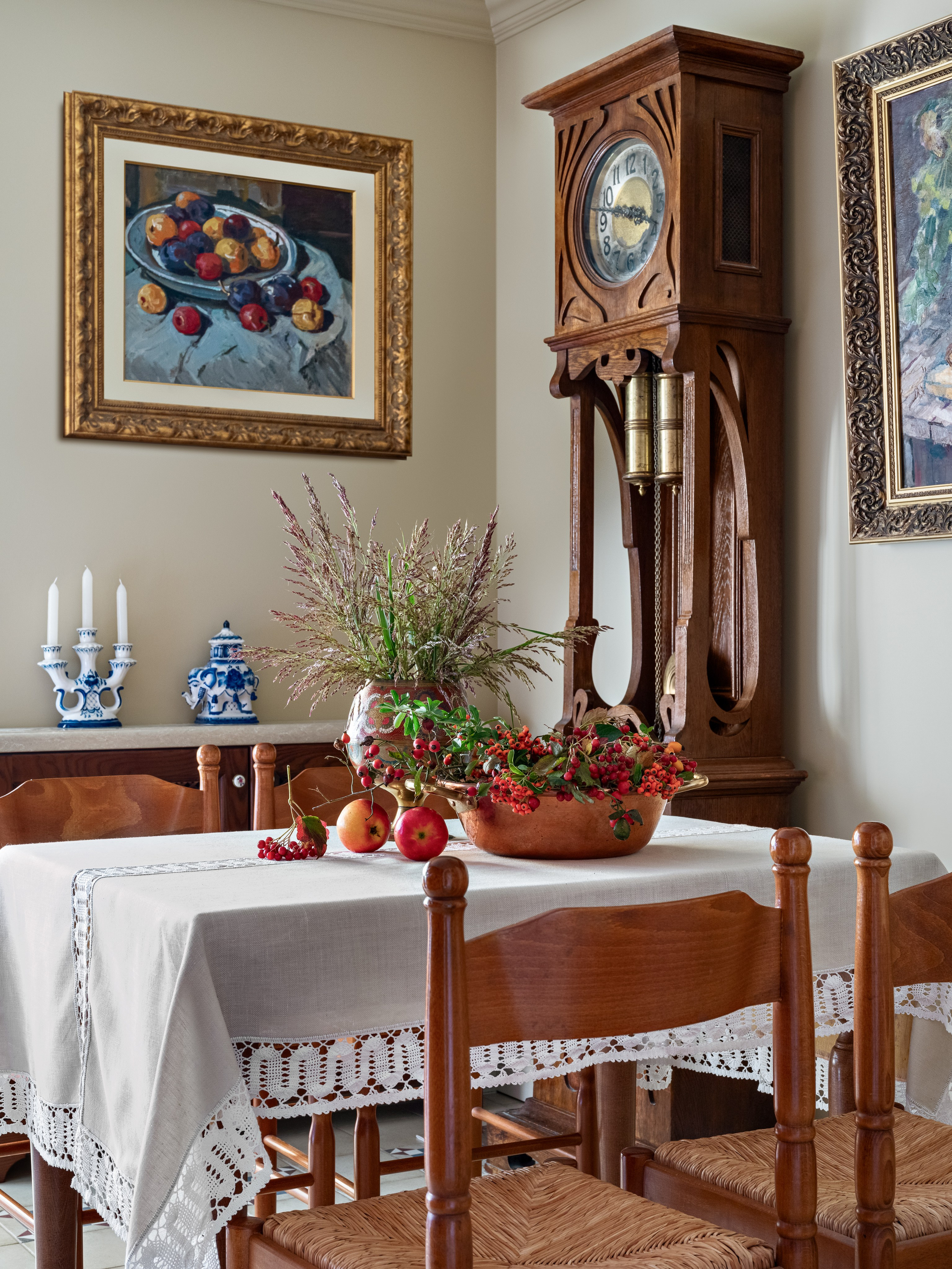 Уютная столовая в классическом стиле: деревянные стулья, стол со скатертью и декором из фруктов и ягод, старинные часы и картины в золотых рамах. Современный интерьер с нотами ретро от Юлии Капункиной и Альбины Терещенко, стилист Алина Нелень, фото Сергей Денисенко.