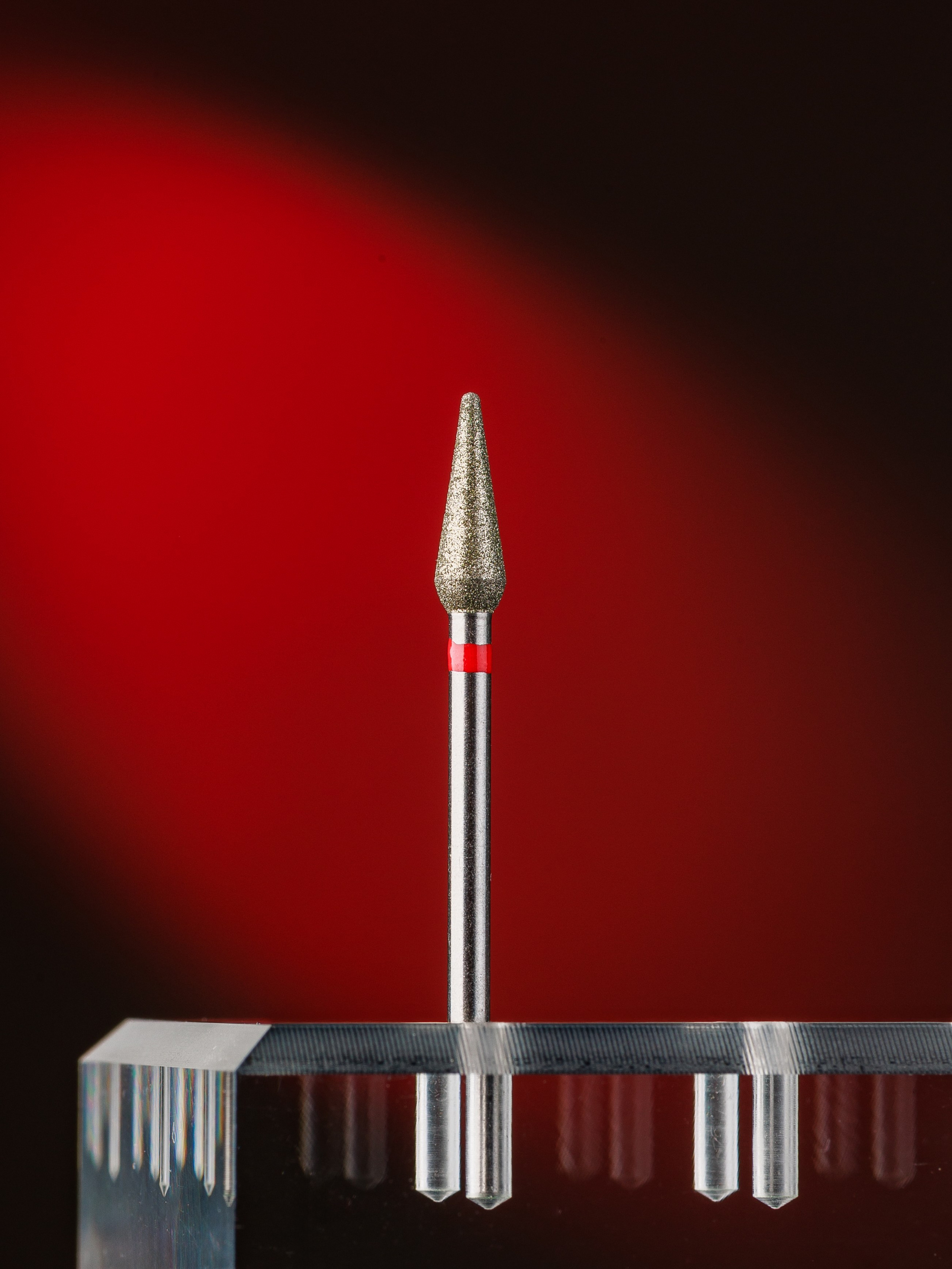 имиджевая предметная съемка фреза для маникюра на красном подсвеченном фоне
