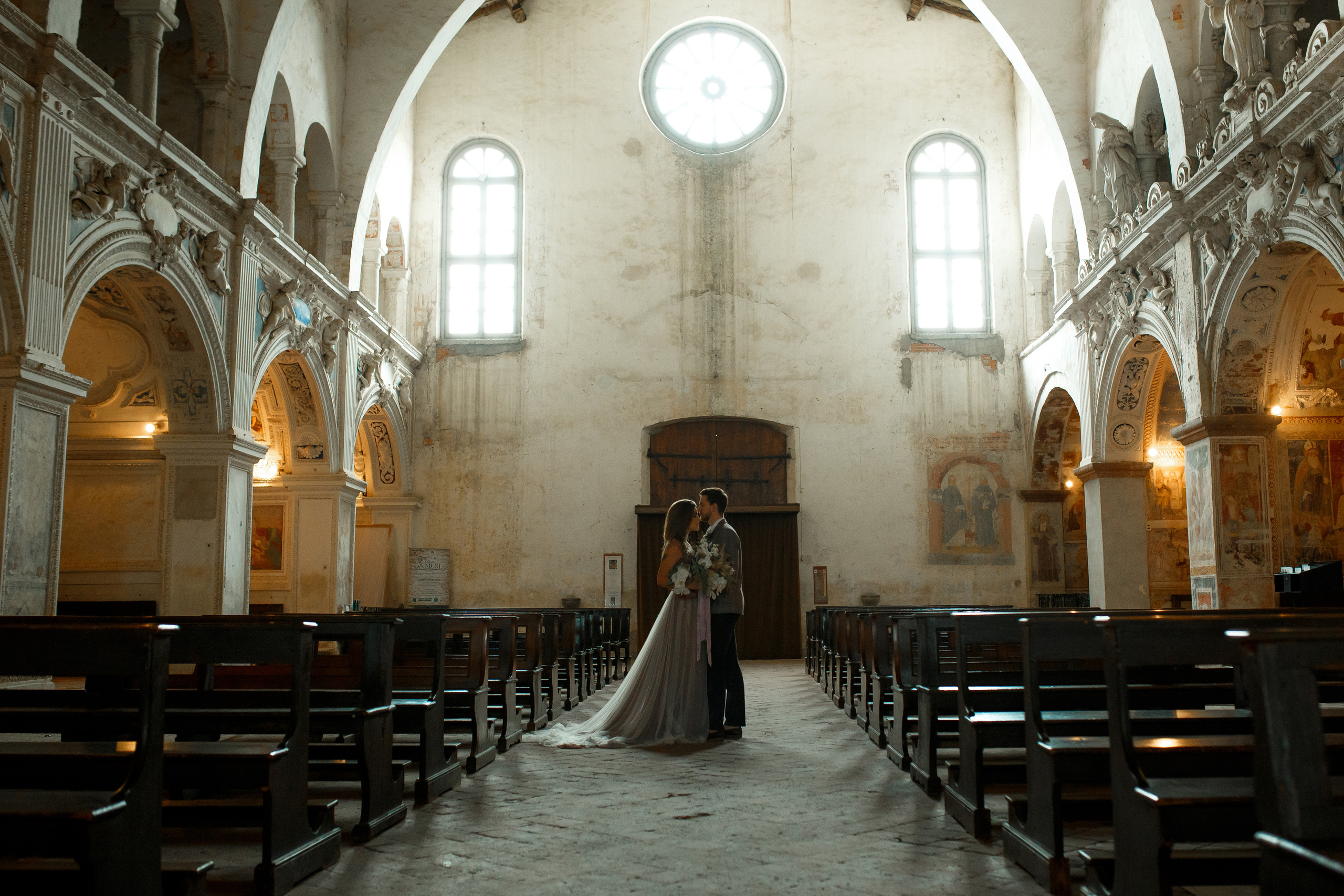 Пара молодожёнов стоит в соборе 