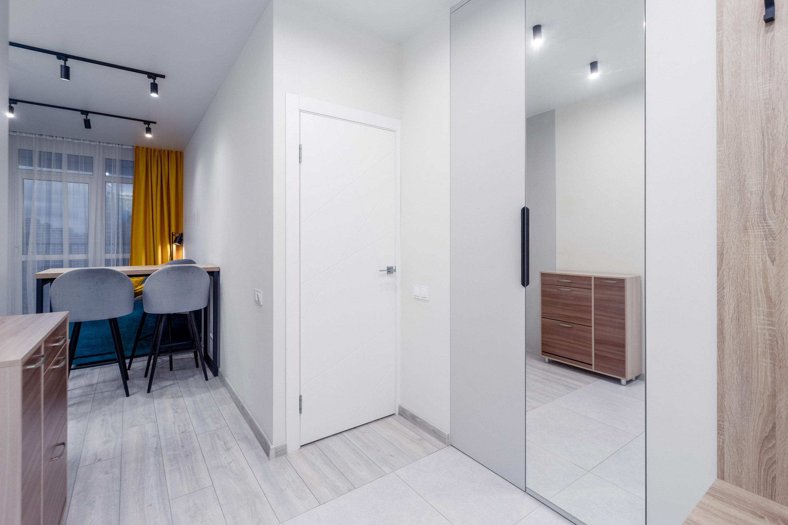 Прихожая с проходом в кухню-гостиную и дверью в спальню в евро-2 квартире в ЖК Минск Мир