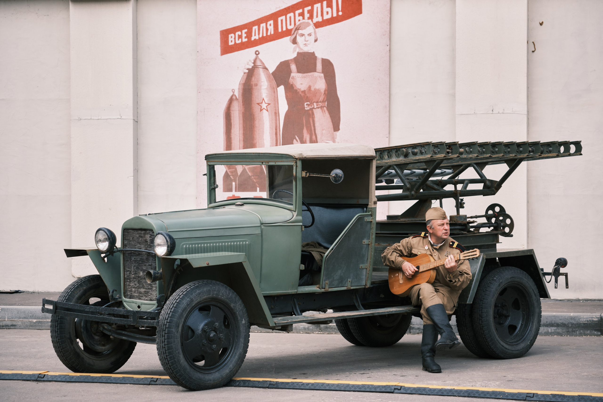 Мужчина играет на гитаре рядом с катюшей Москва 1945г