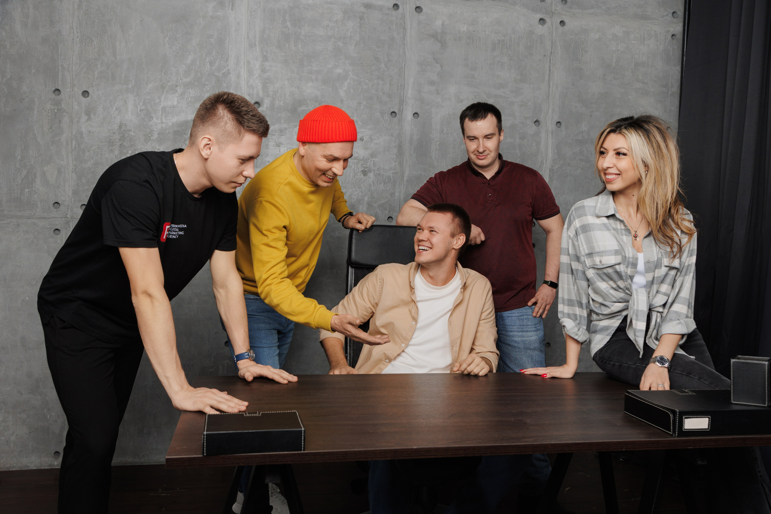 Команда сотрудников активно обсуждает рабочий вопрос в переговорной зоне офиса.