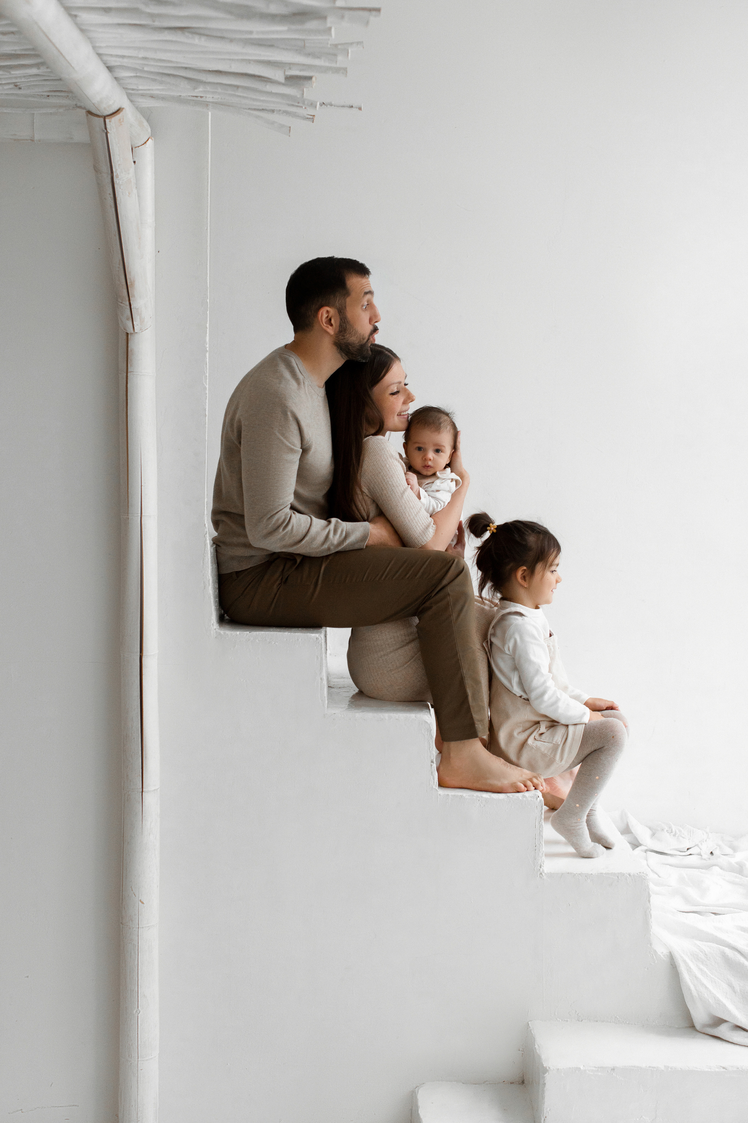 Семья с дочкой и сыном сидят на лестнице в студии Мимика 