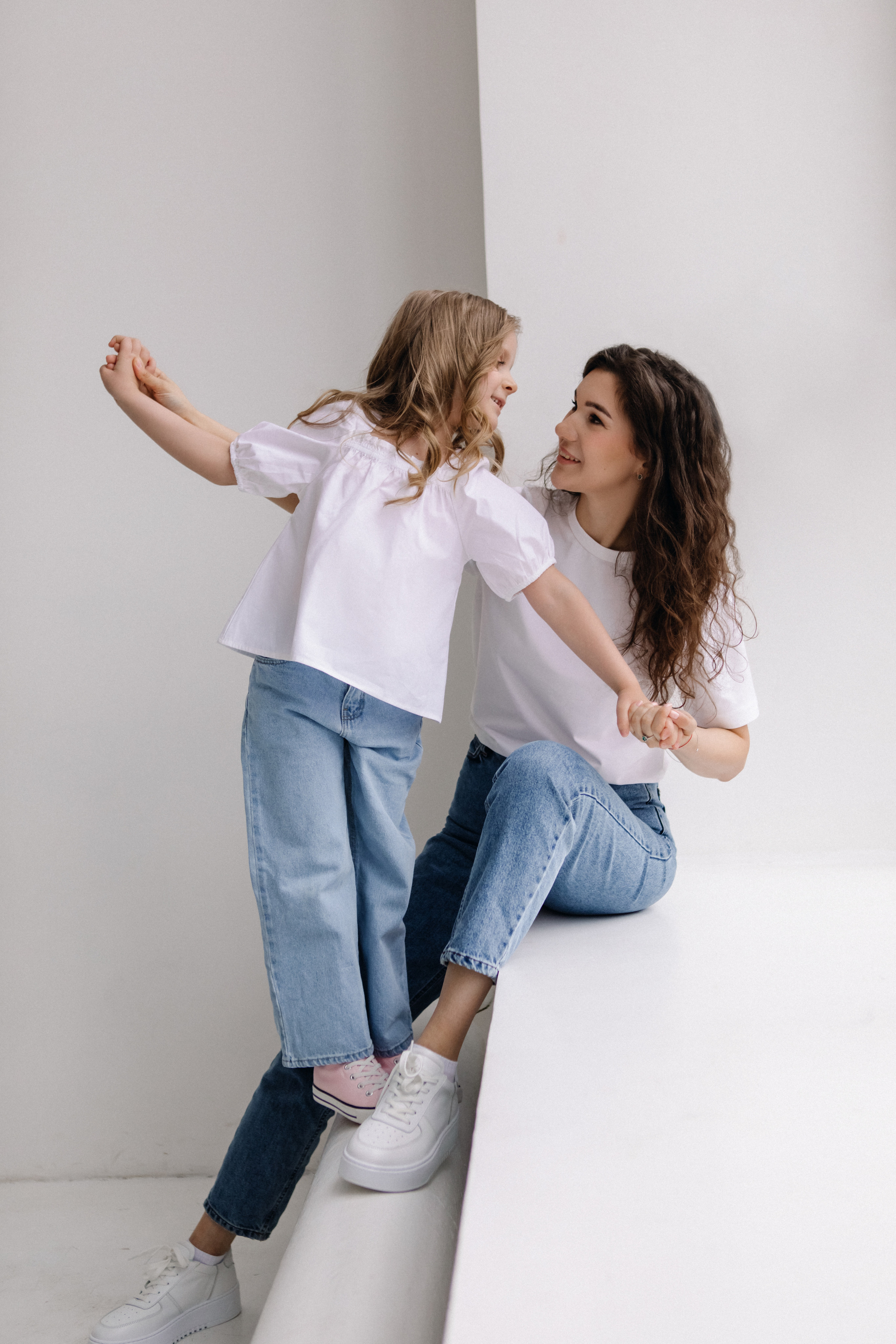 Мама и дочка сидят на окне