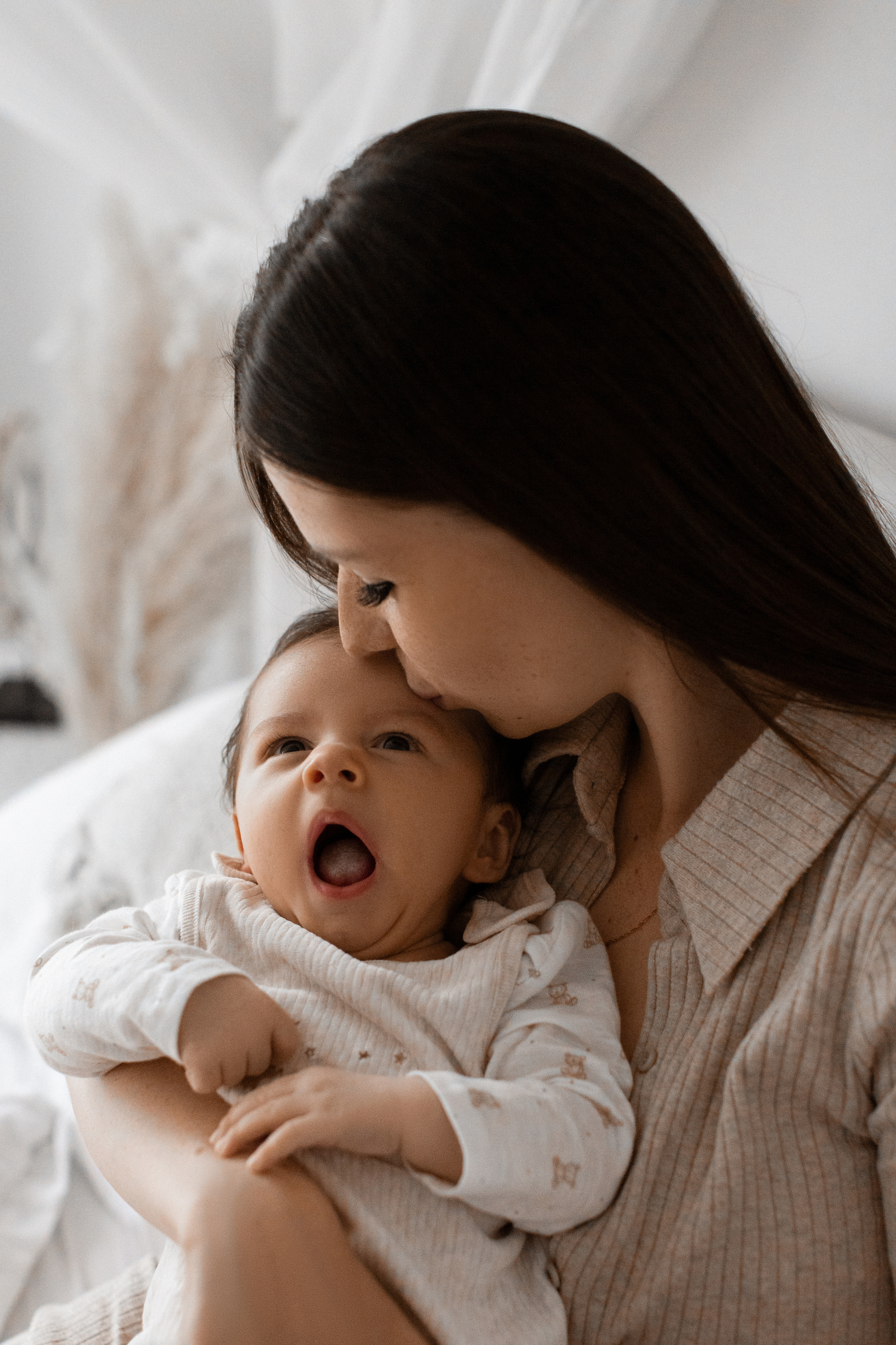 Малыш зевает на руках у мамы