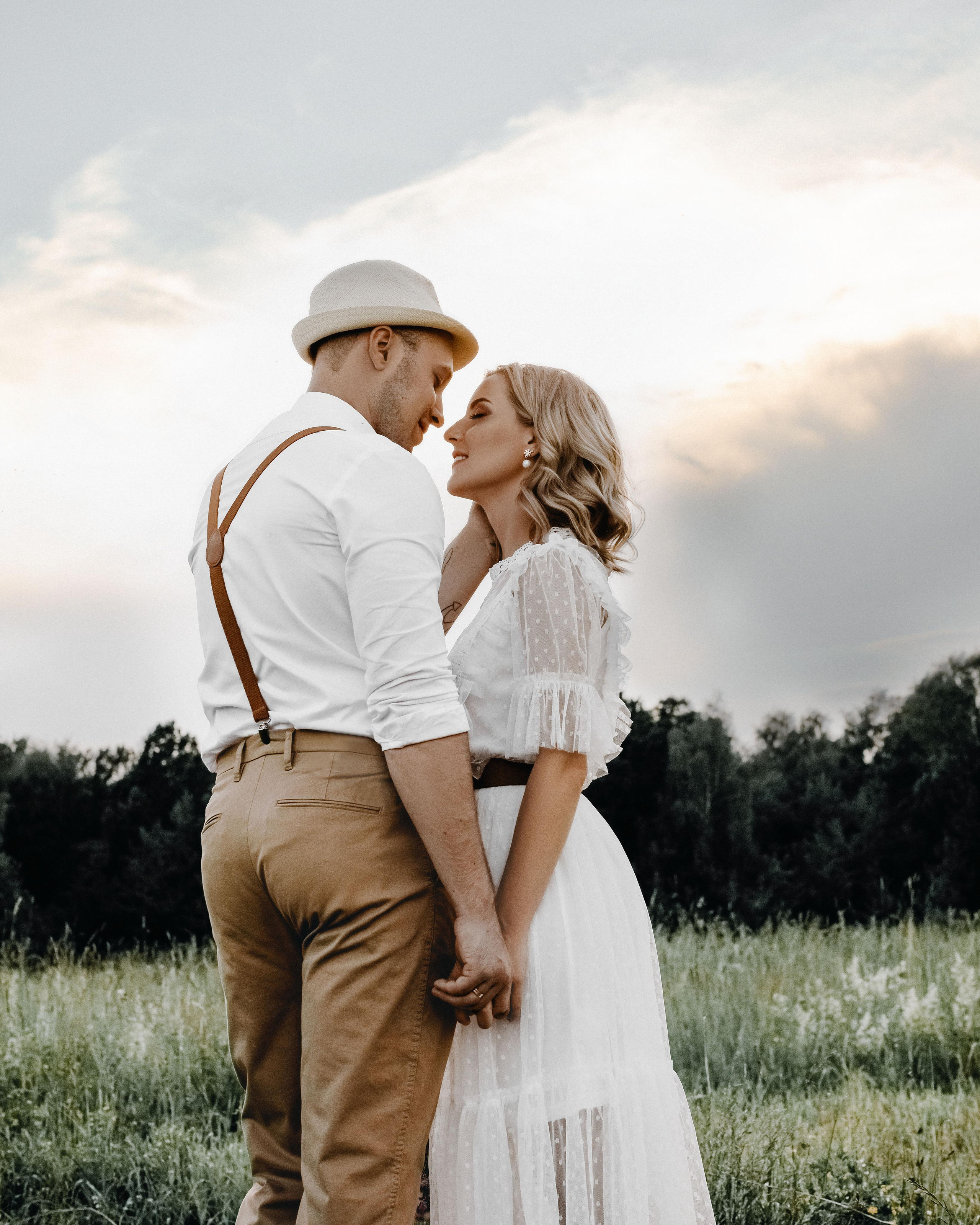 Поцелуй влюбленной пары на закате на природе