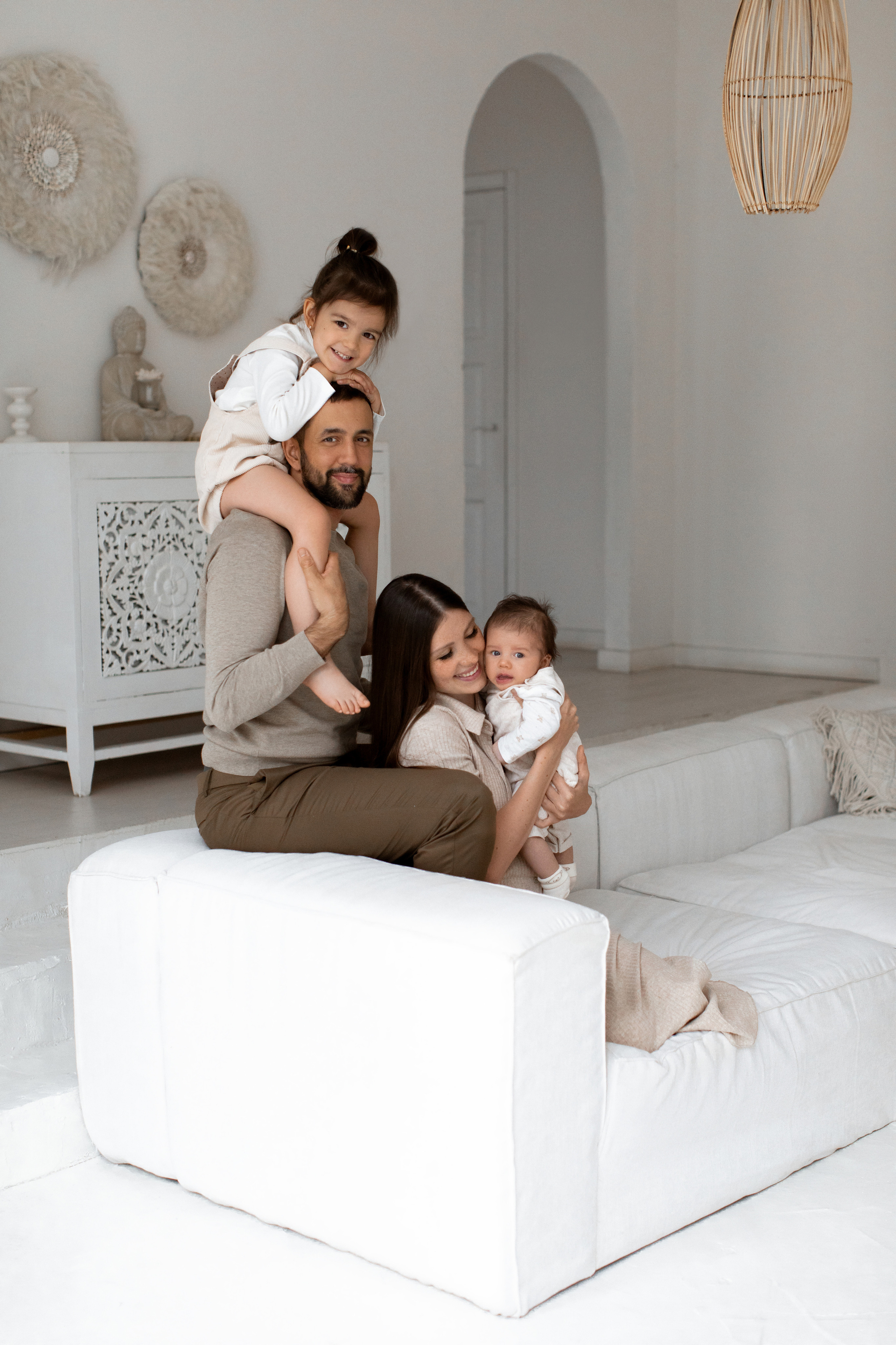 Счастливая семья из 4 человек сидят на диване