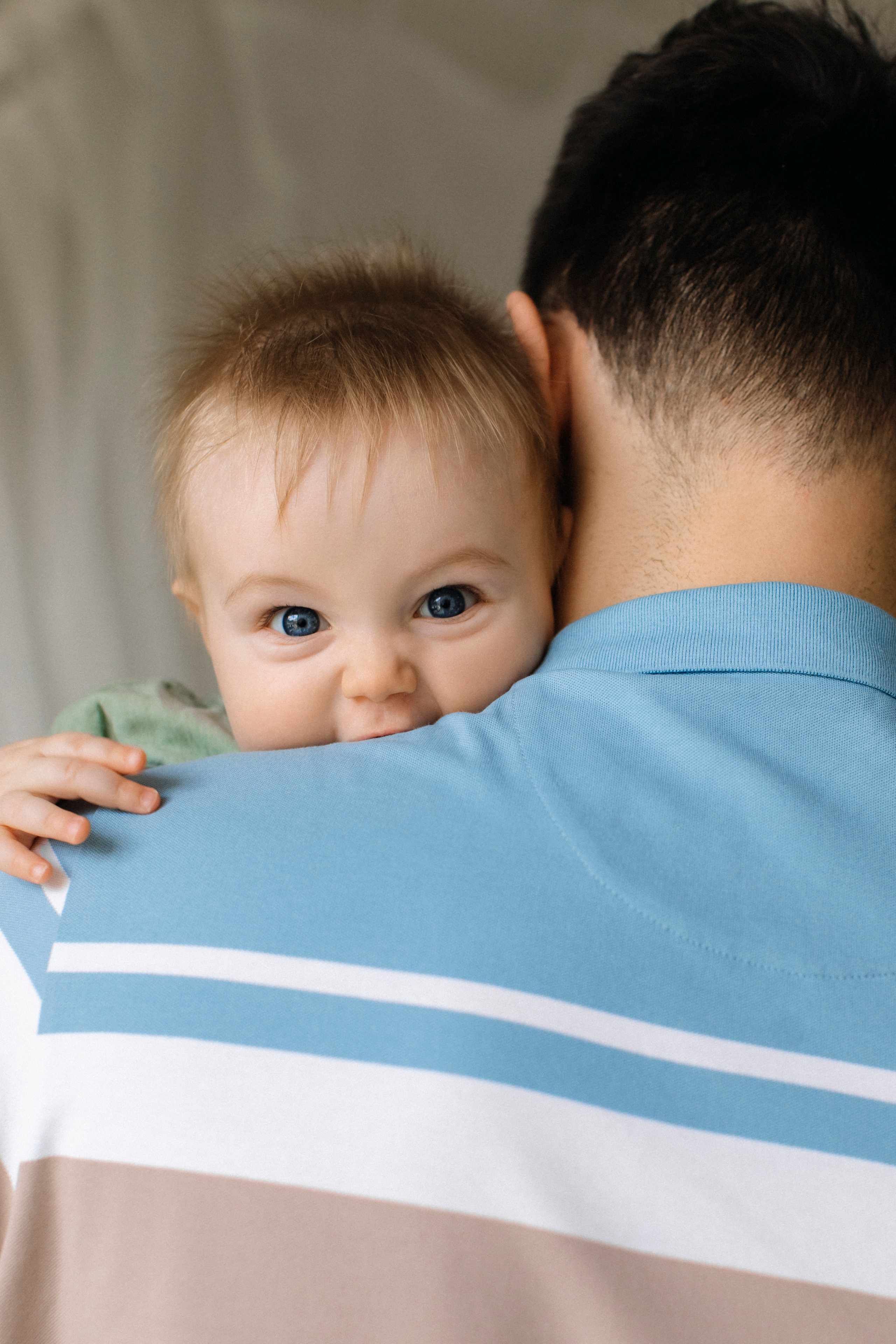 Ребенок на руках у папы смеется