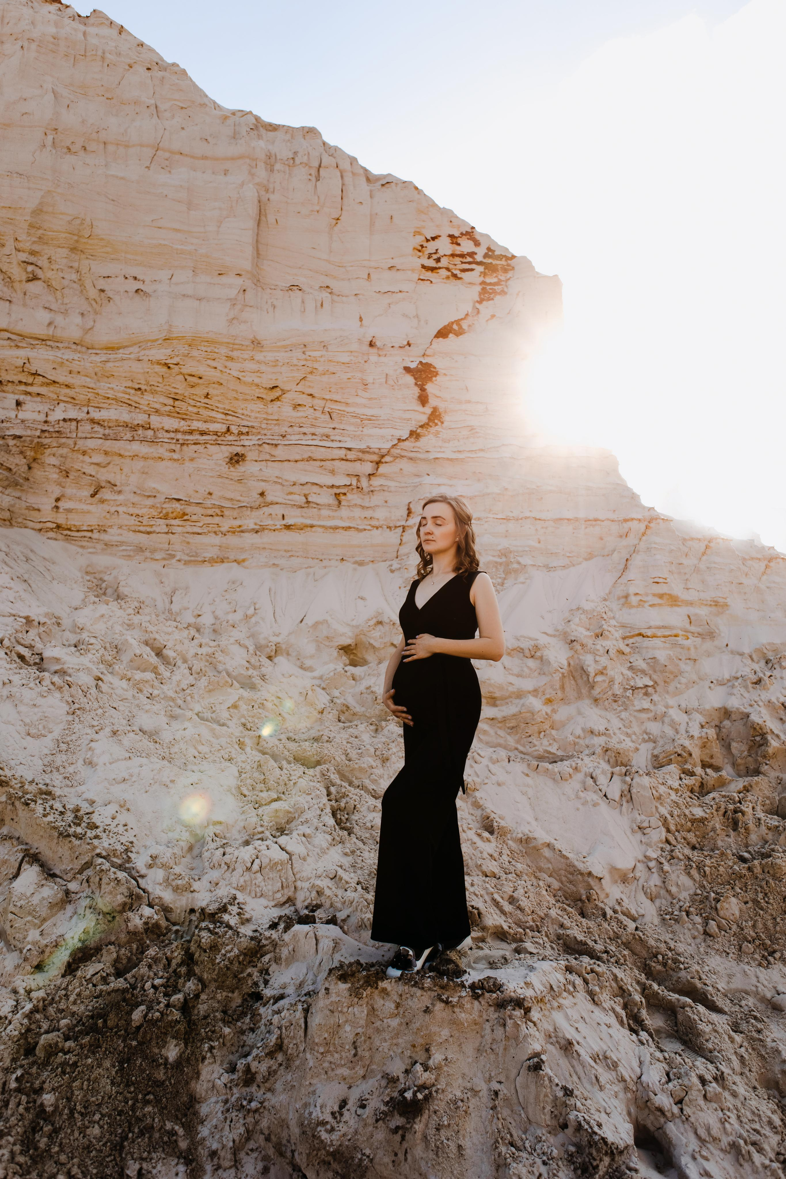 Фотосессия беременной в черном комбинезоне на улице 