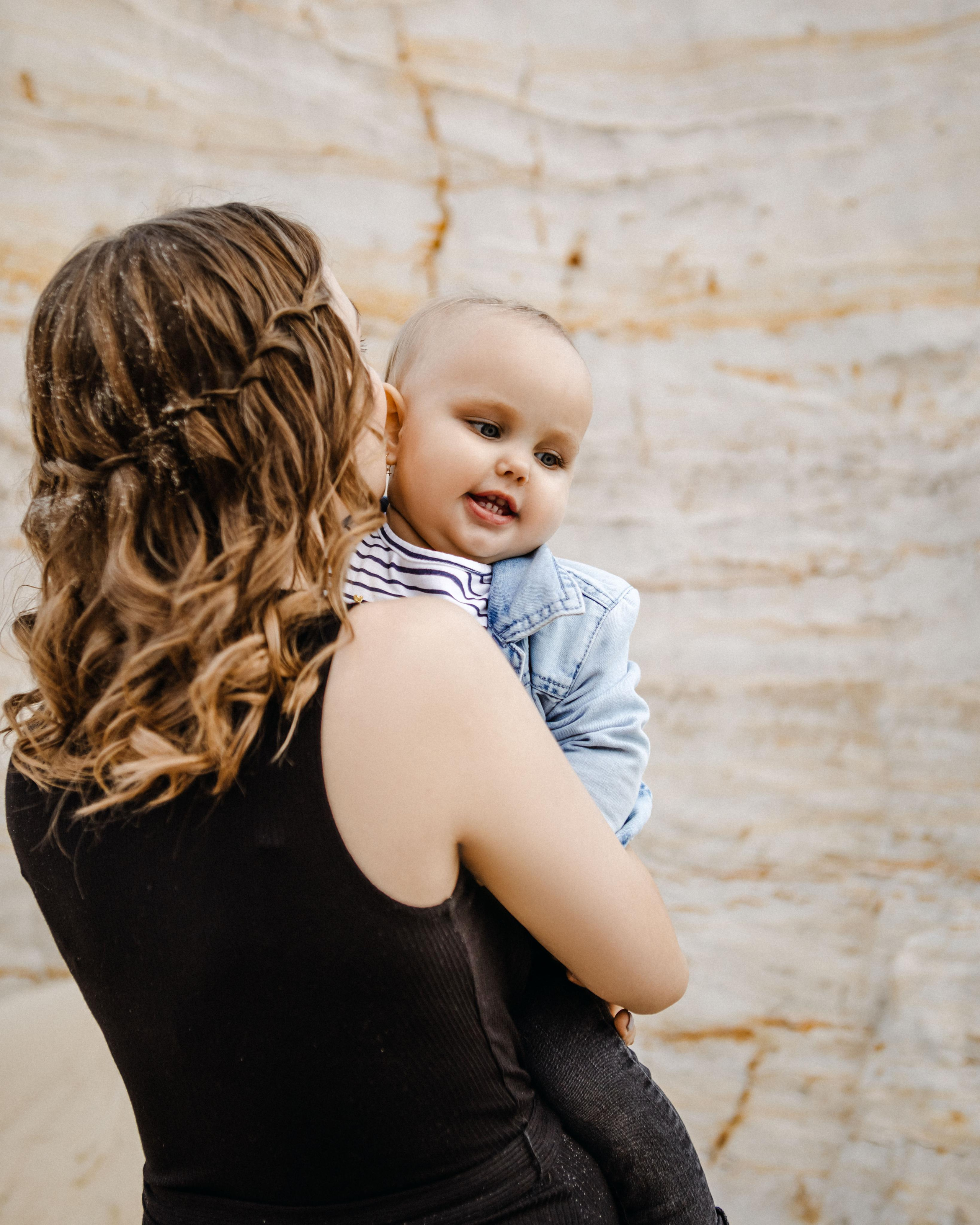 Мама целует ребенка на руках