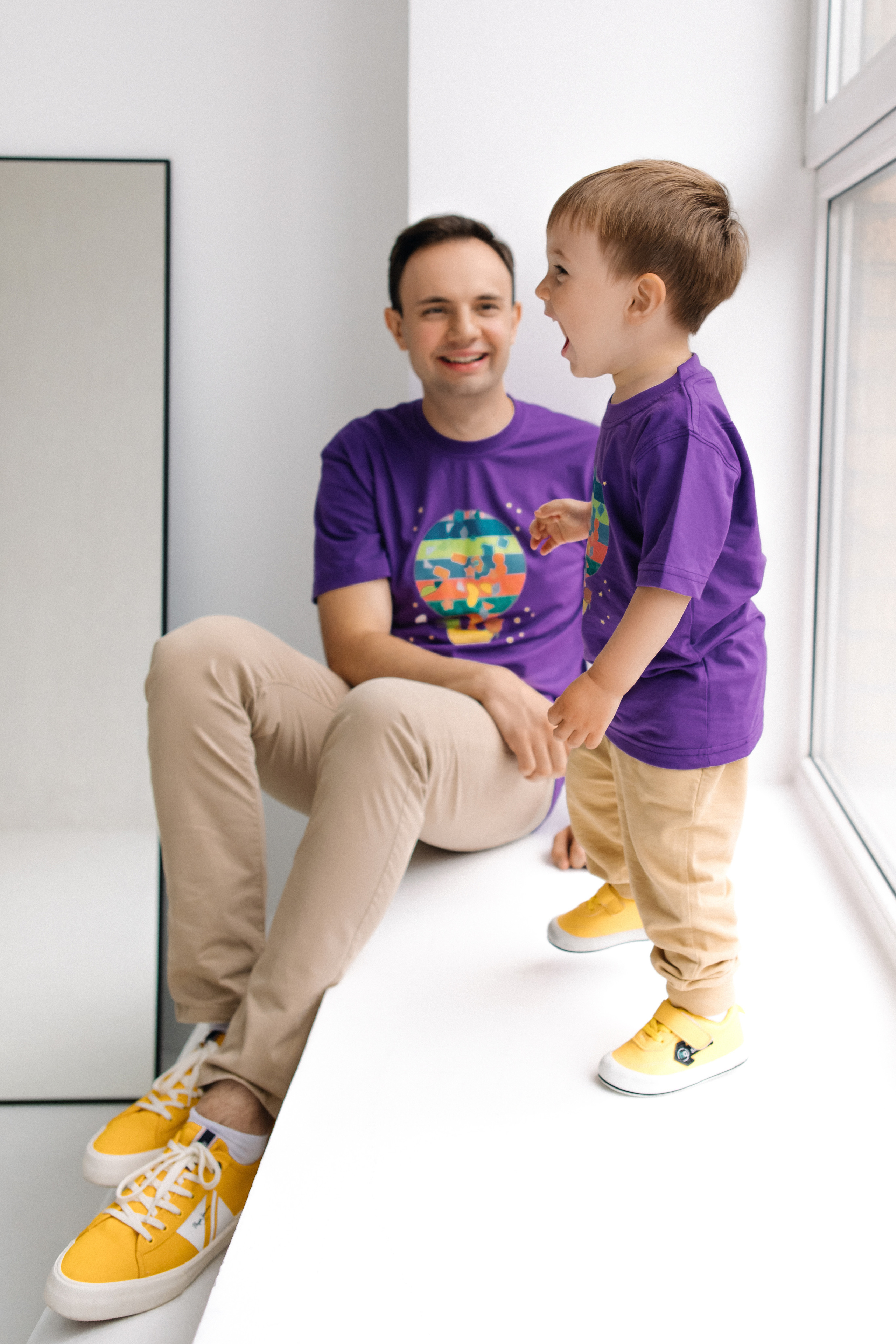 Отец и сын у окна в светлой студии