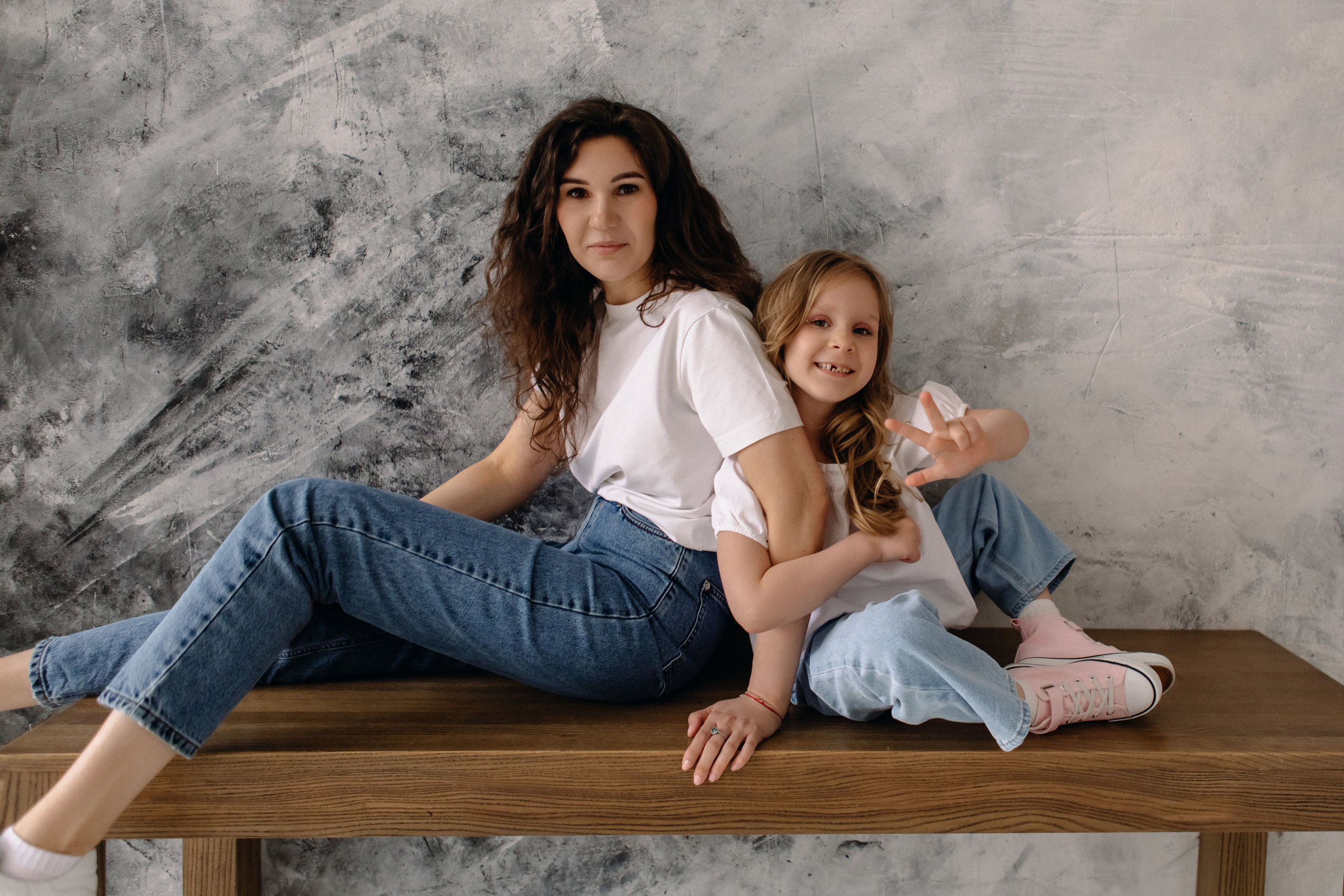 Мама и дочь сидят на столе