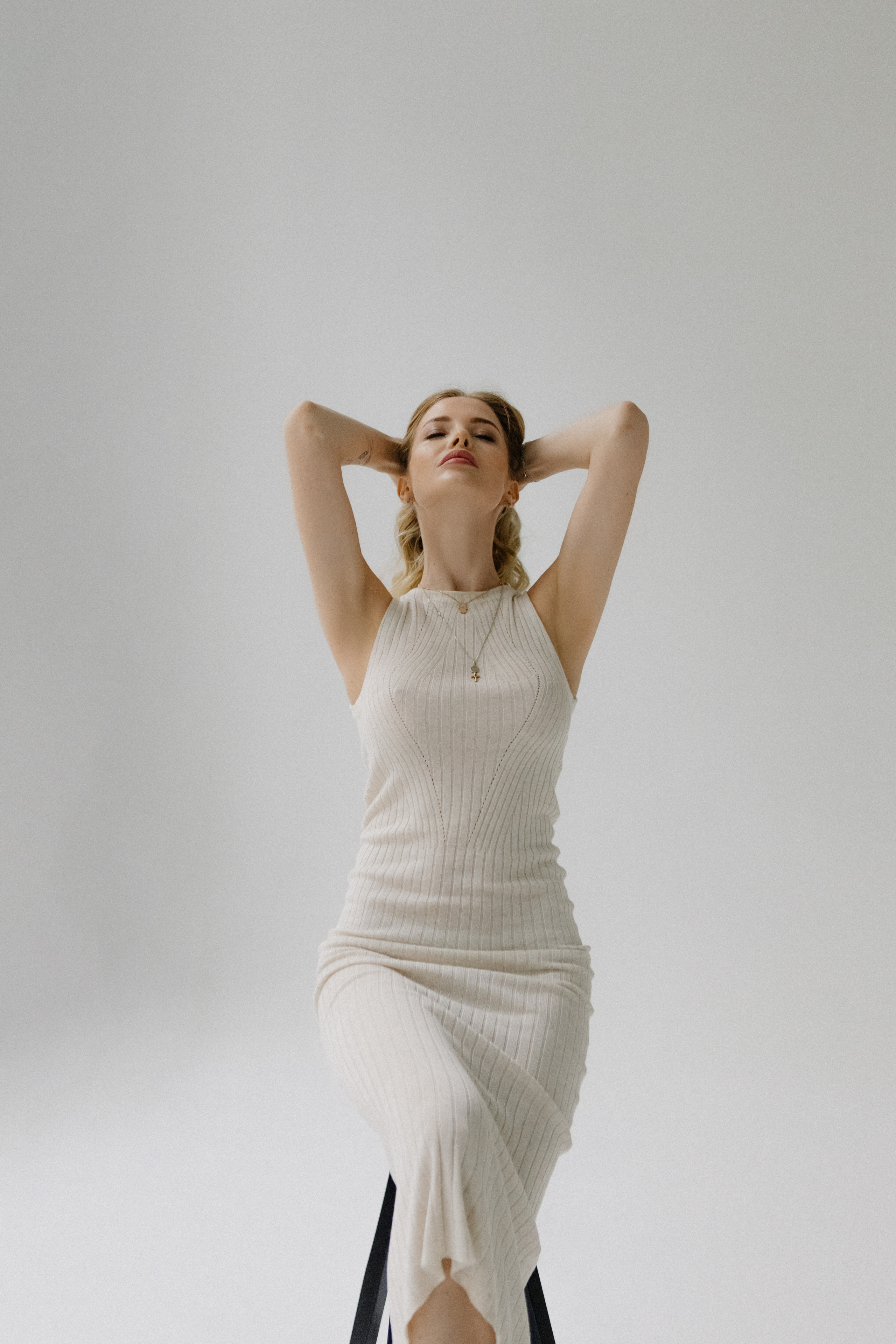 Девушка в позе на стуле в платье лапша