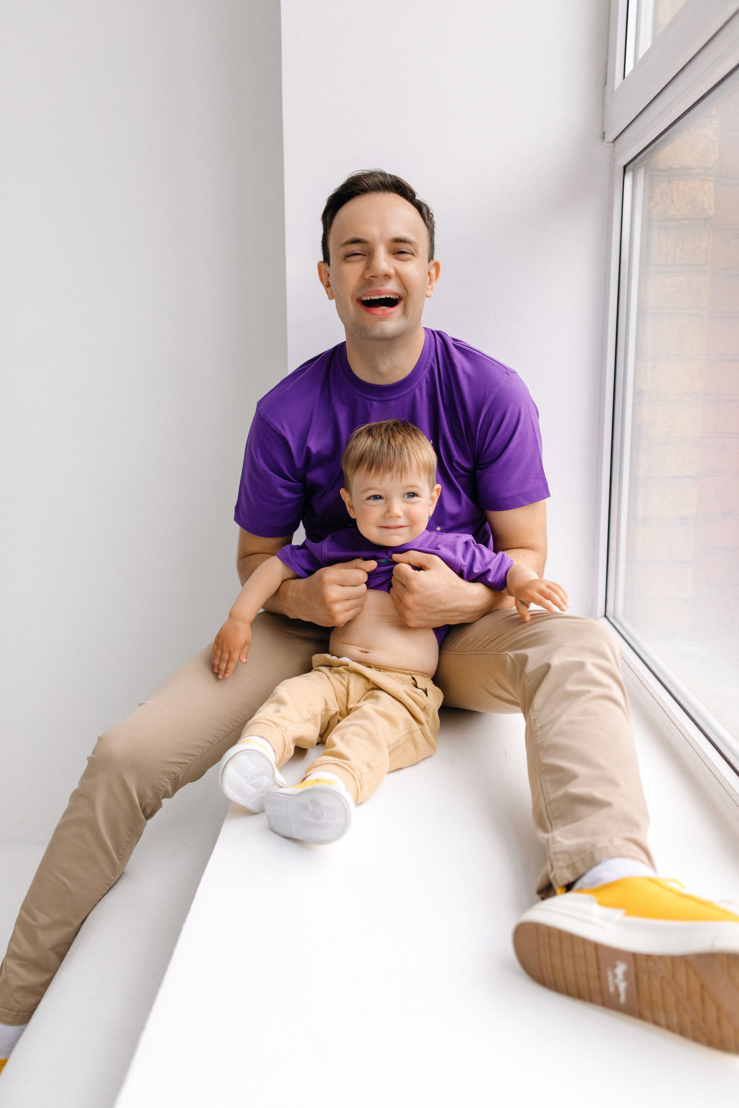 Папа и сын сидят на окне