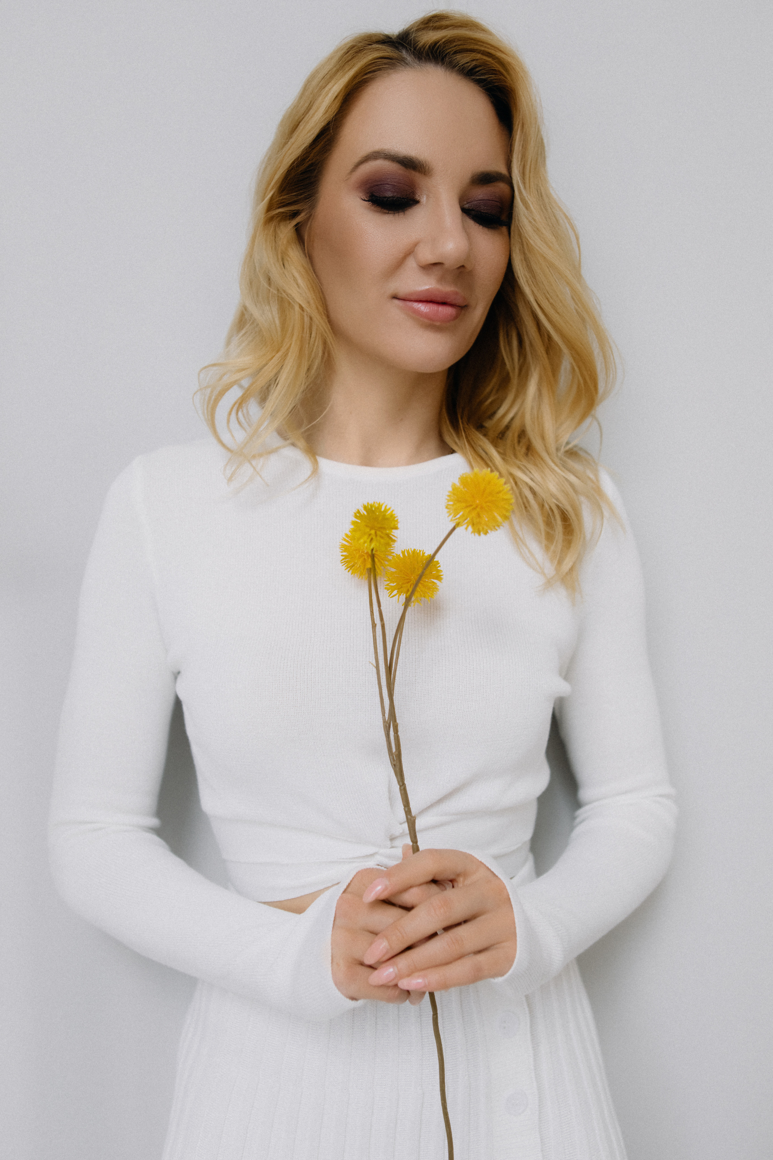 Блондинка с цветком в белом костюме