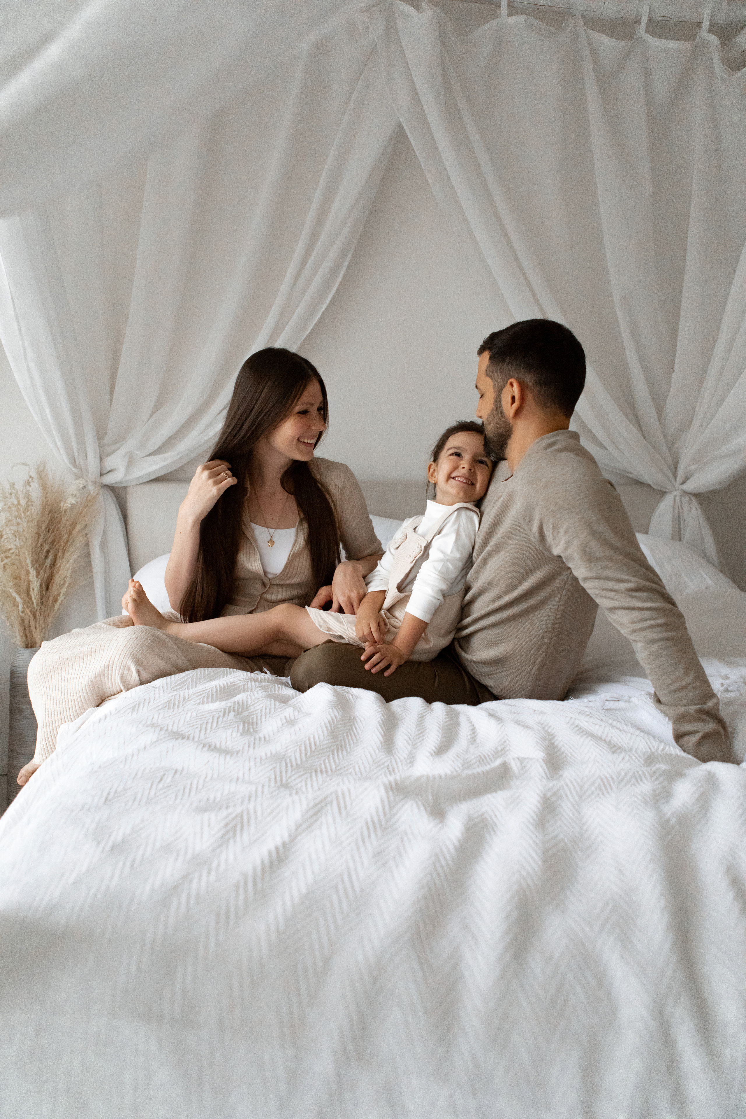 Мама и папа с дочкой на кровати зал Убудет Мимика