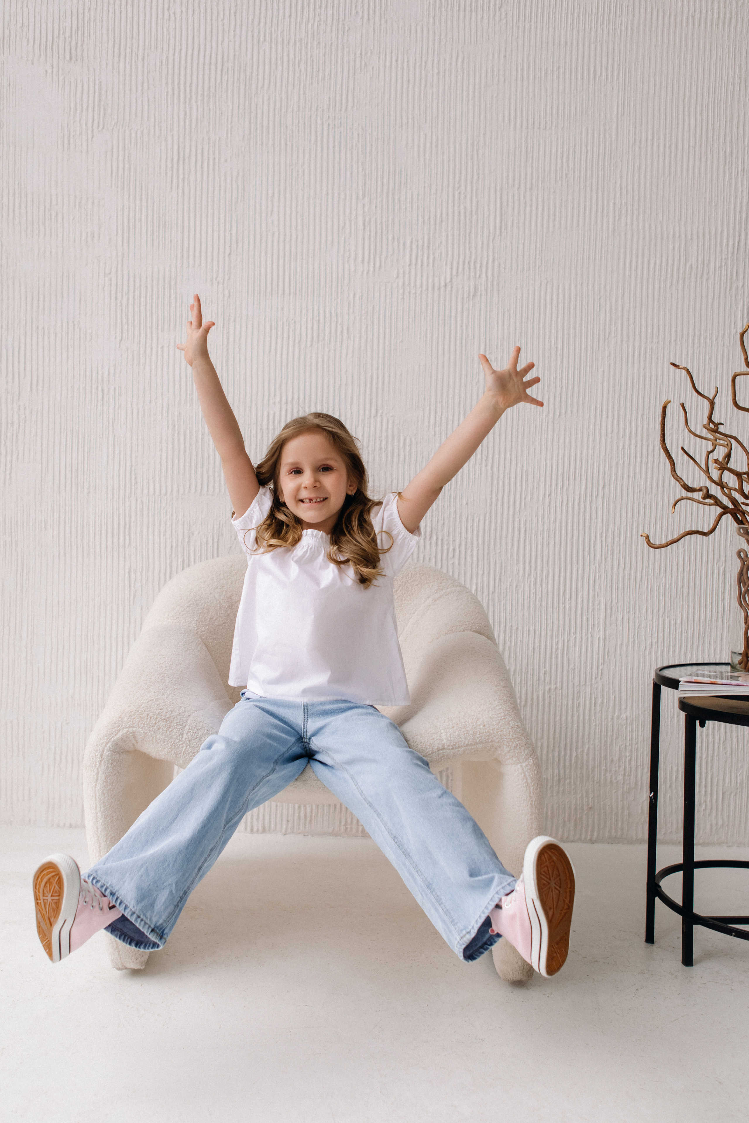 Счастливая девочка сидит в кресле в светлой студии зал Бланш