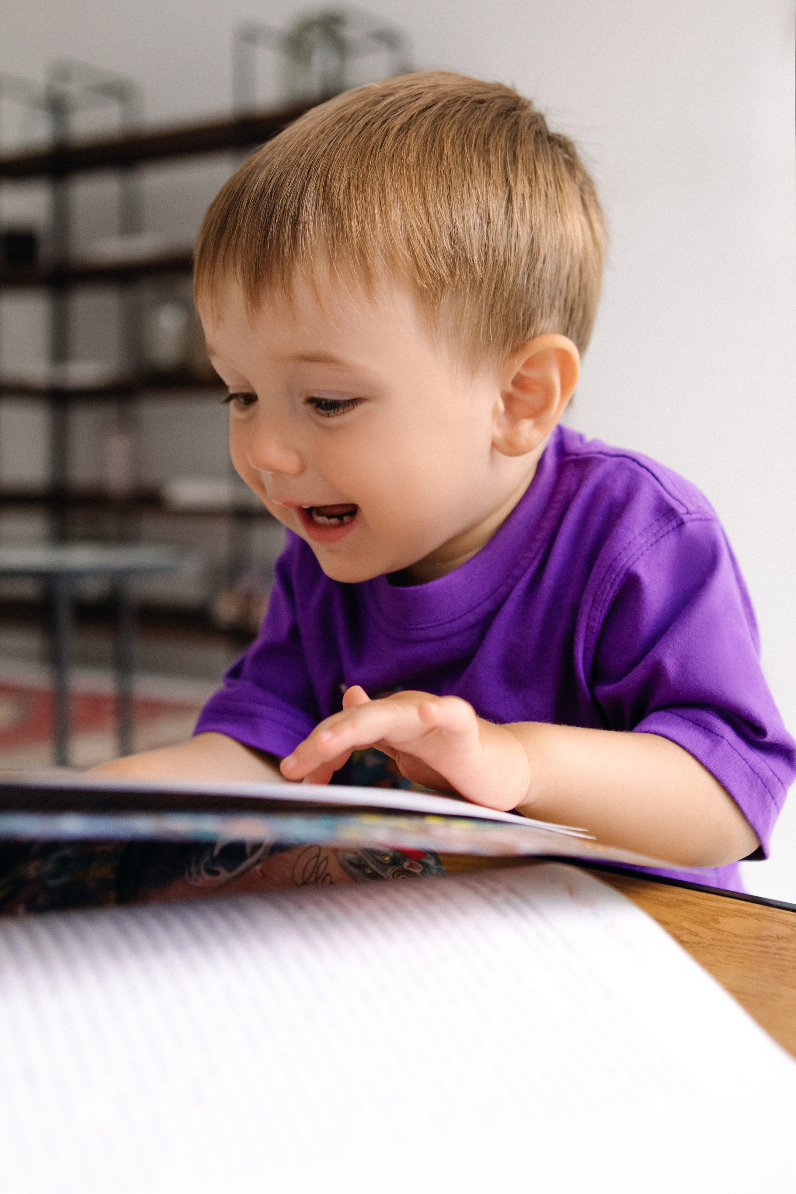 Малыш читает детскую книжку и улыбается