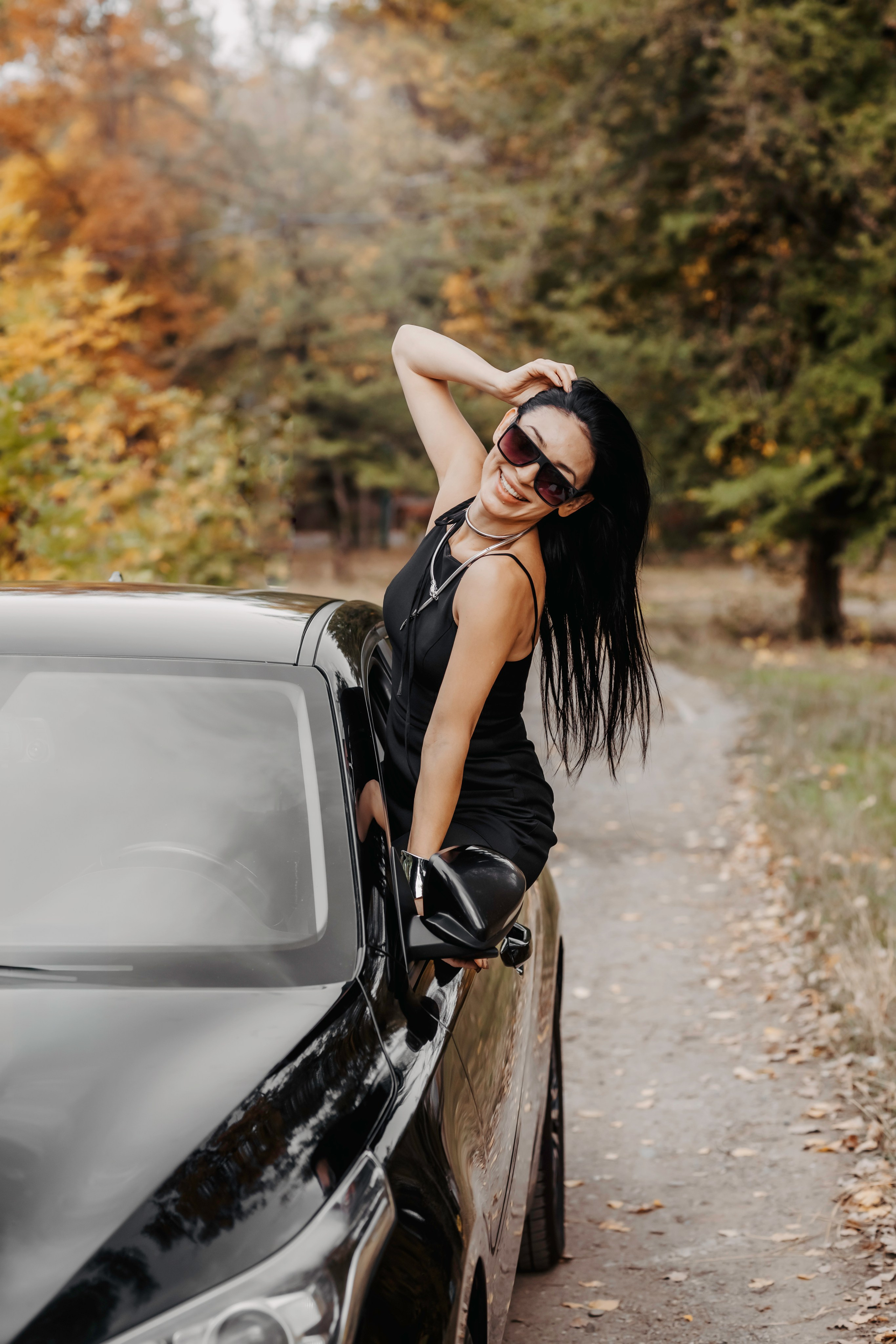 Атмосфера осени: девушка у своей машины, окружённая красками золотой листвы