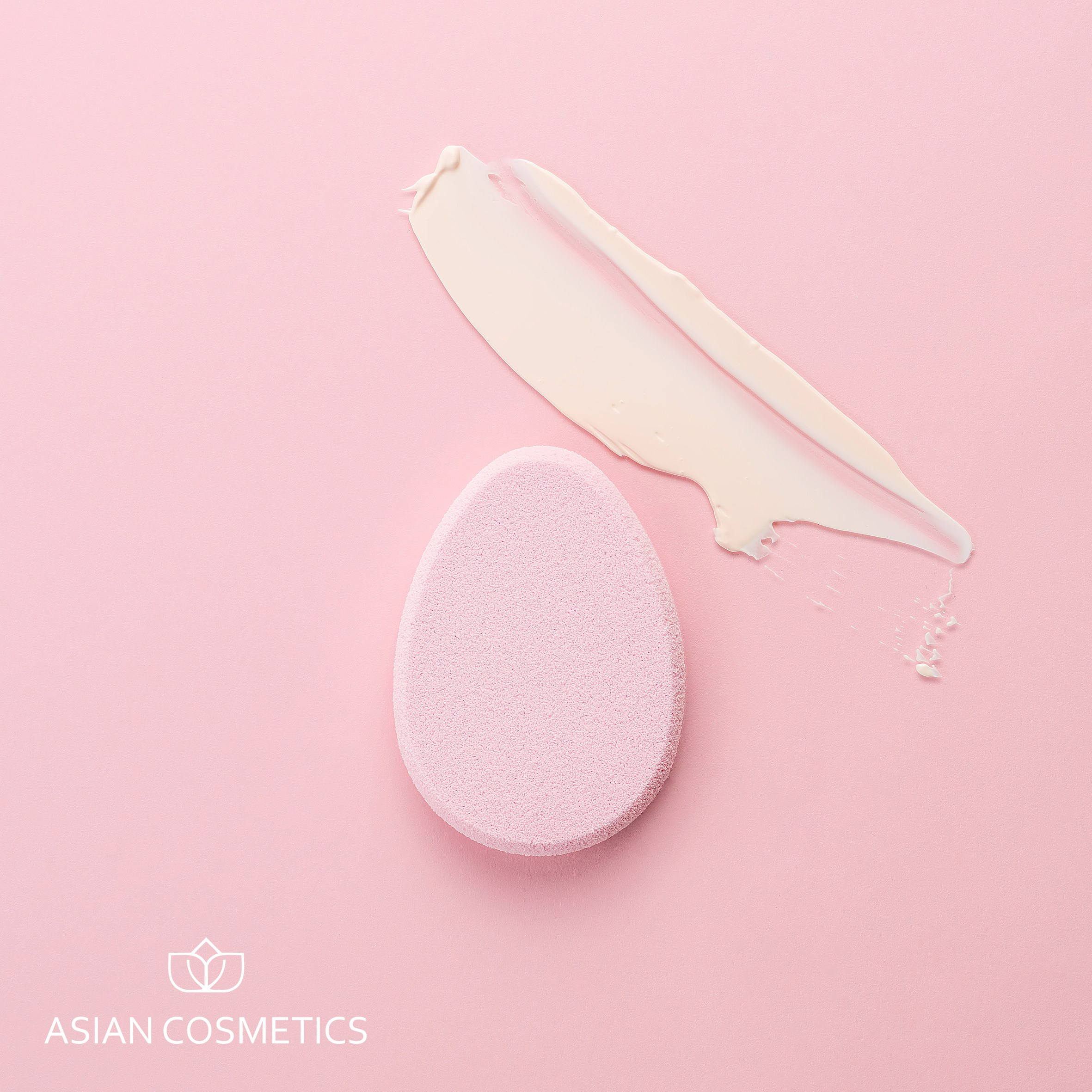 Каталожная фотосъёмка косметического спонжа в форме капли и кремовой текстуры, розовый фон, крупный план деталей, для онлайн-продаж.