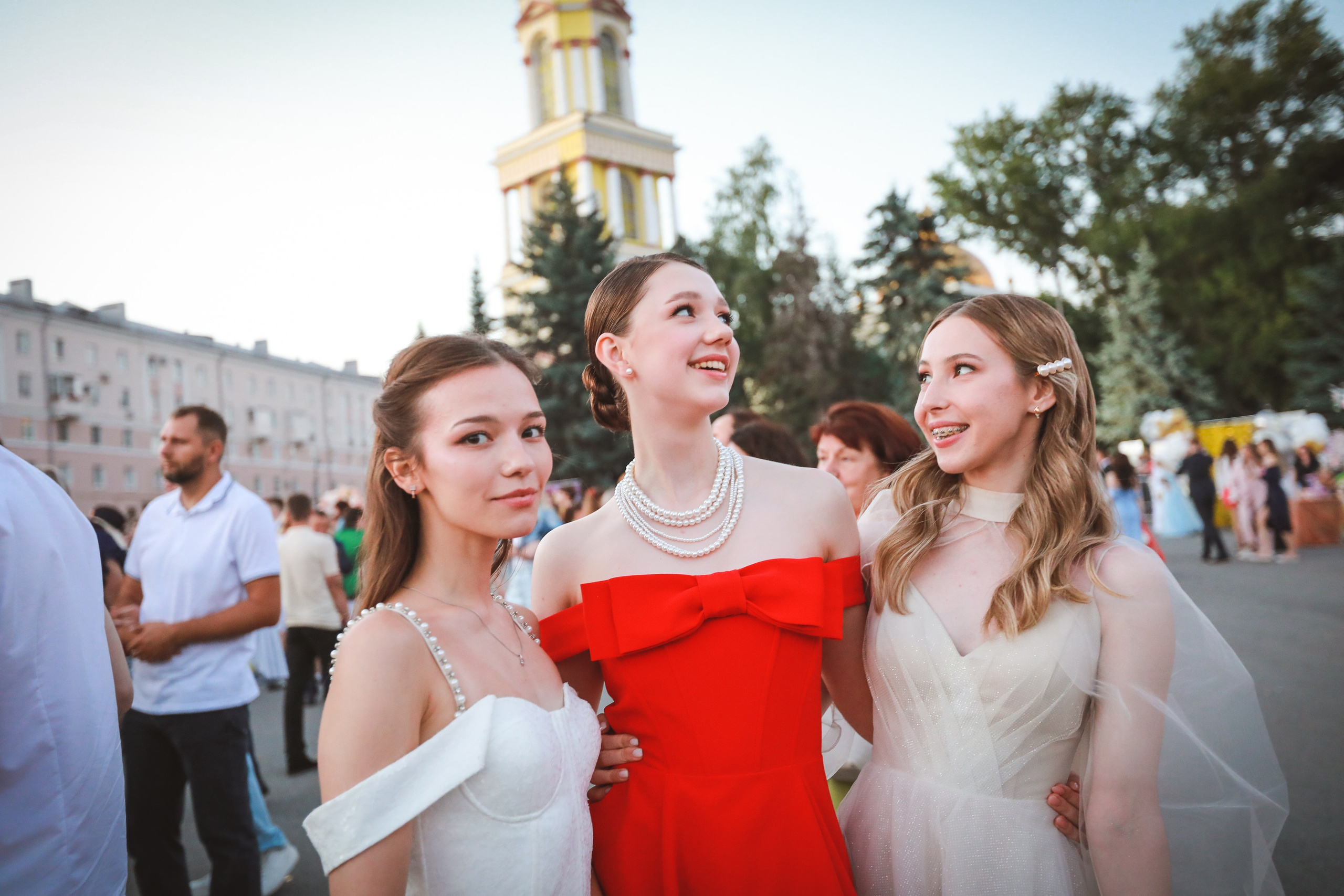 Красивые девушки в стильнох платьях, в красном платье на выпускном школьном балу.