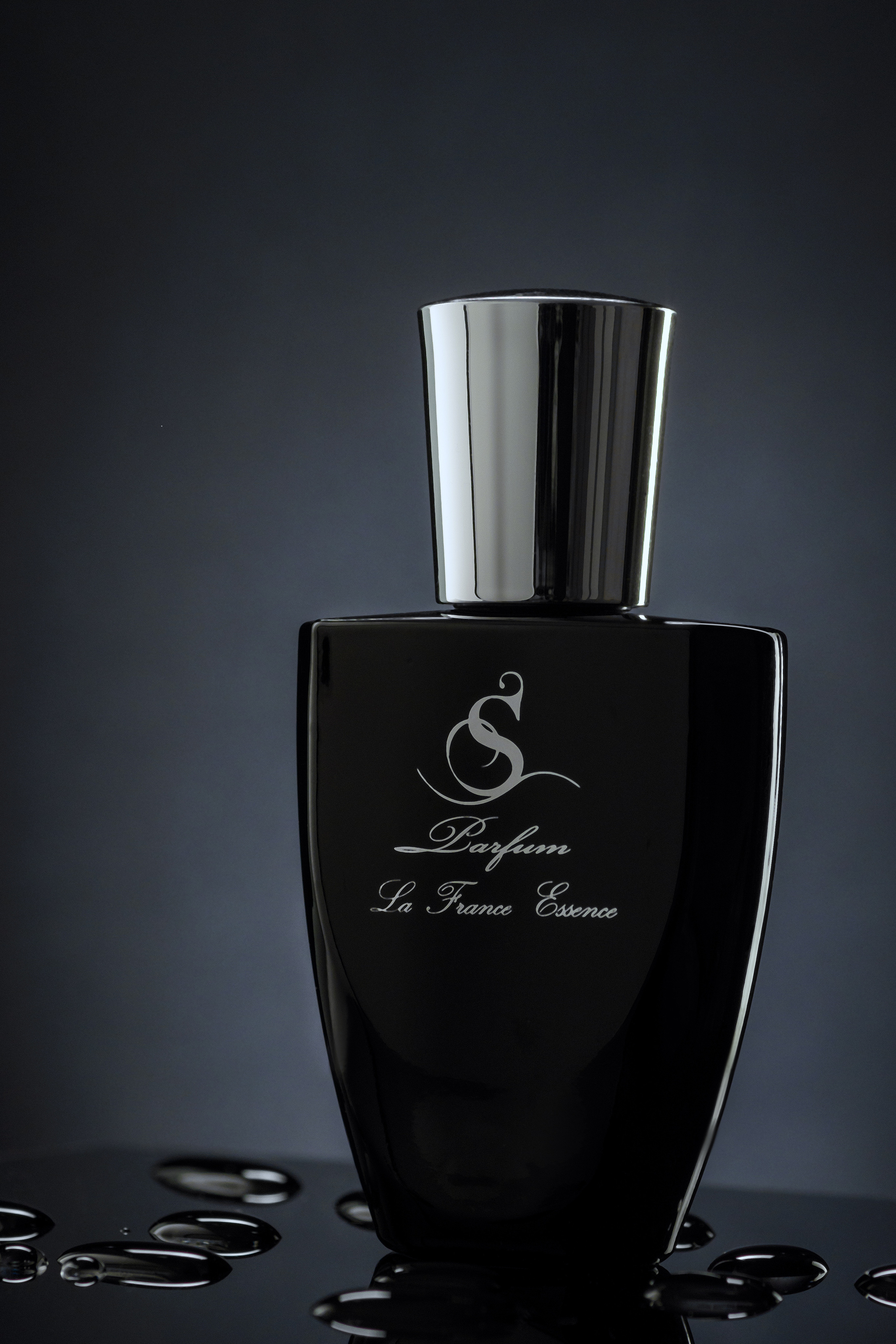 черный флакон духов с каплями воды на стекле