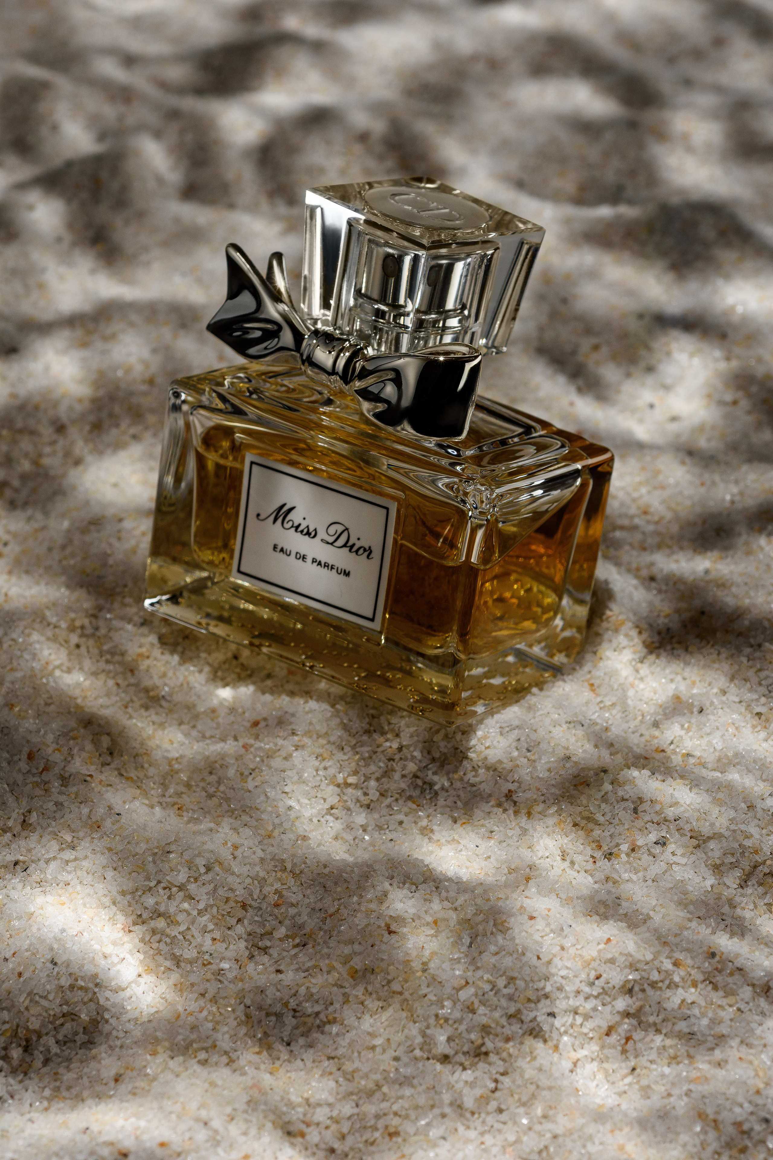 флакон духов Miss Dior на морском дне и солнечными отражениями