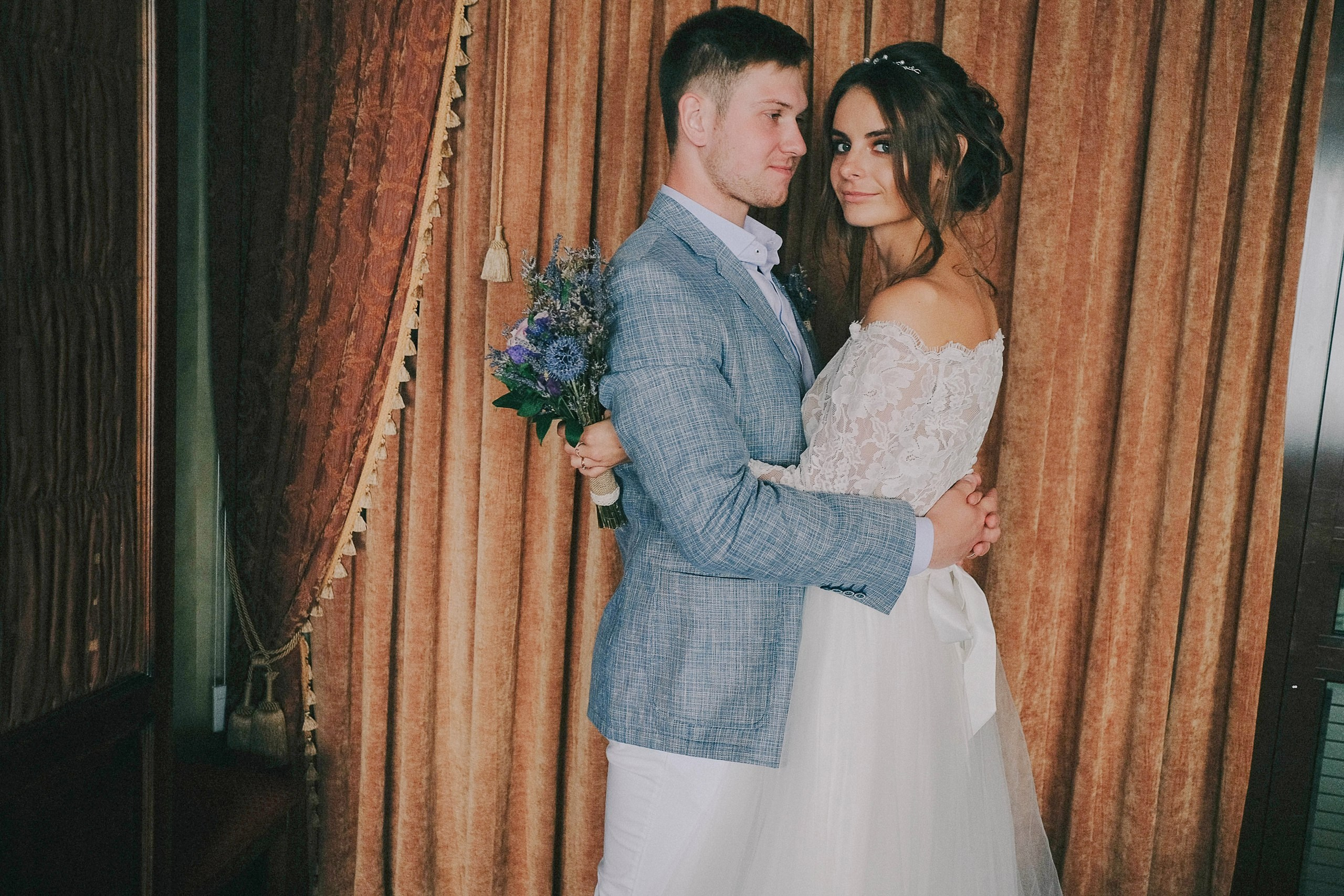 Объятия молодоженов на фоне номере отеля Новосибирска