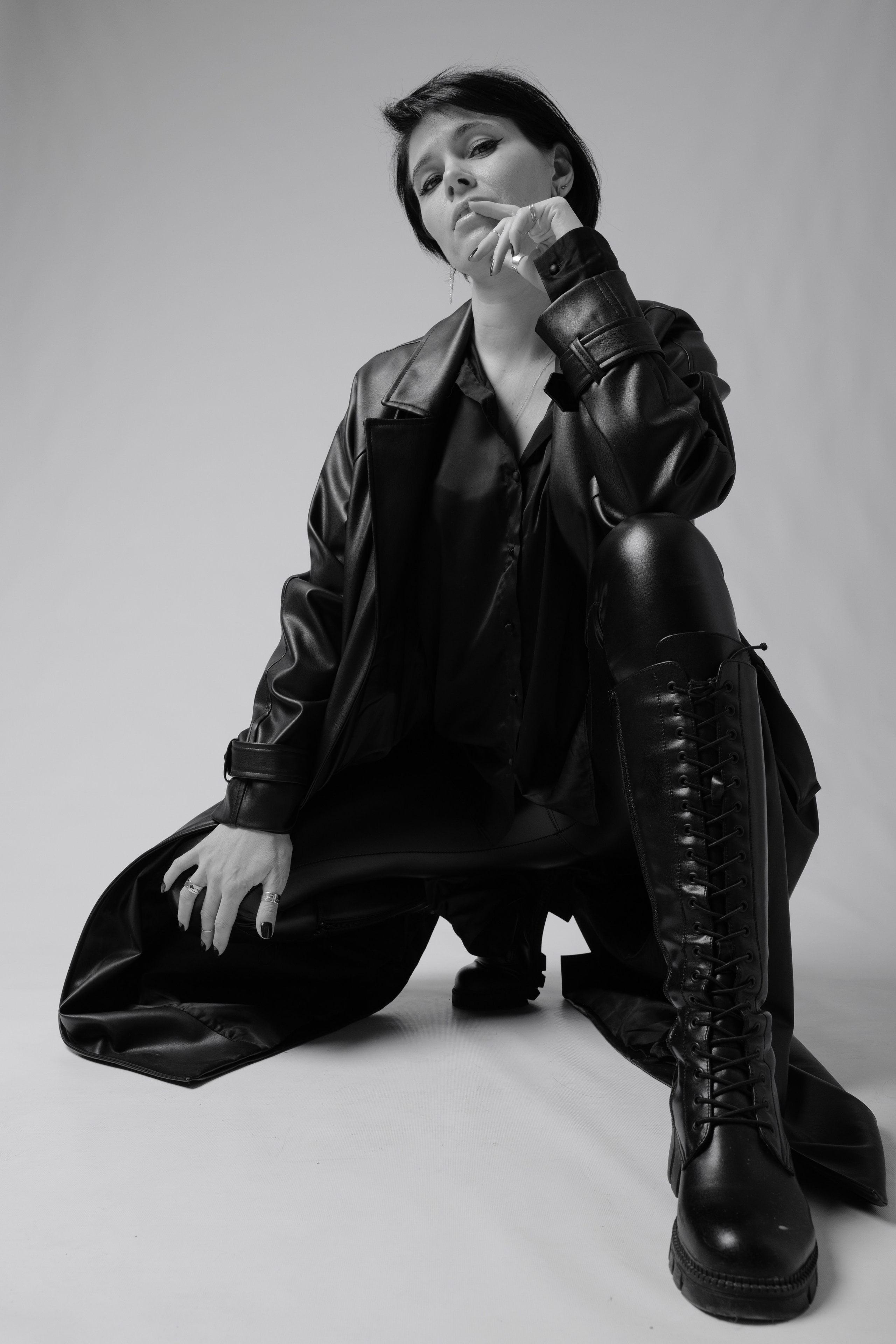 Черно-белый портрет в студии девушка в черном плаще.