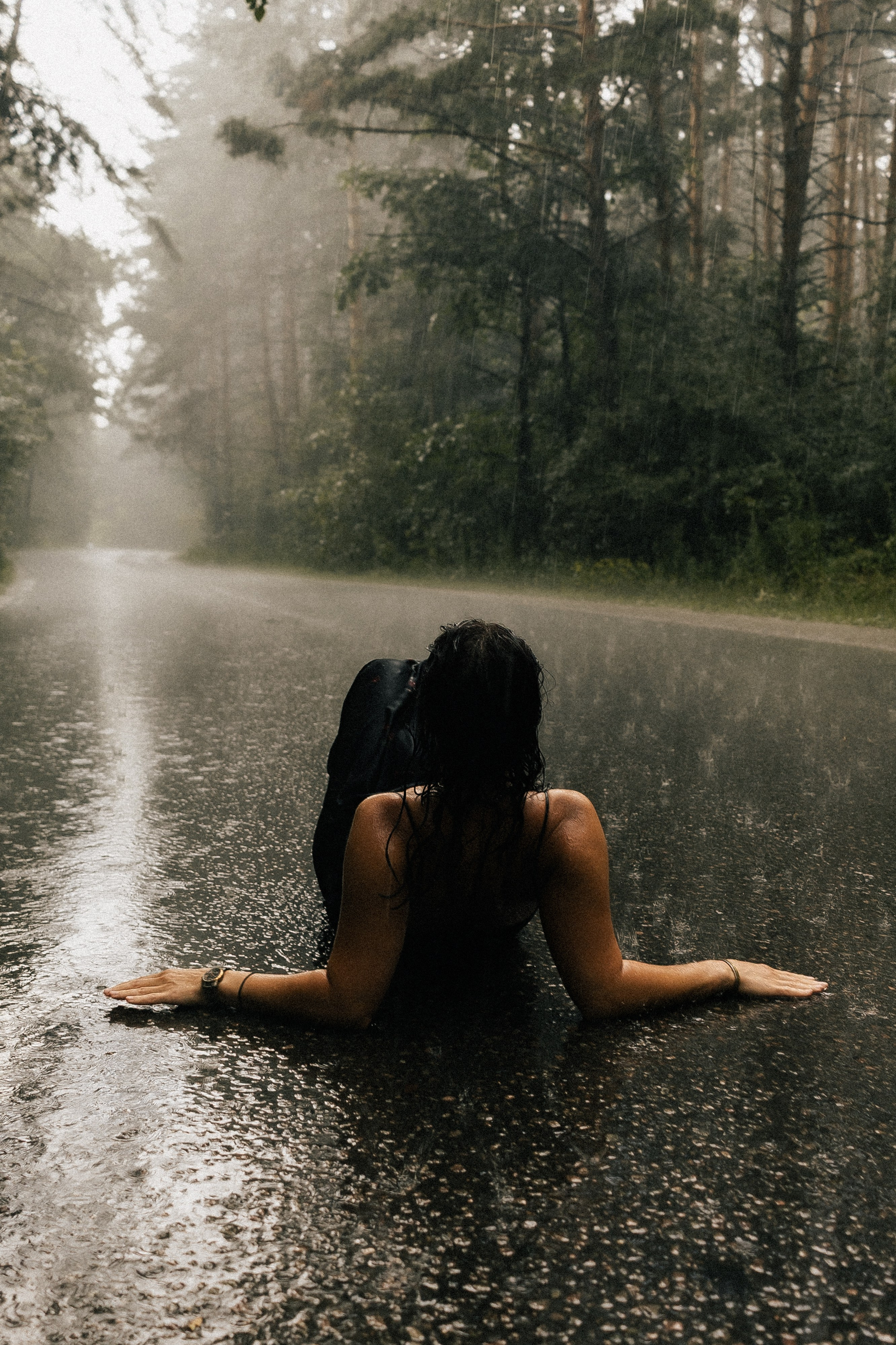 Девушка сидит на мокрой дороге в тумане под сильным ливнем, драматичный кадр. Фотограф в Пензе Александра Овечкина