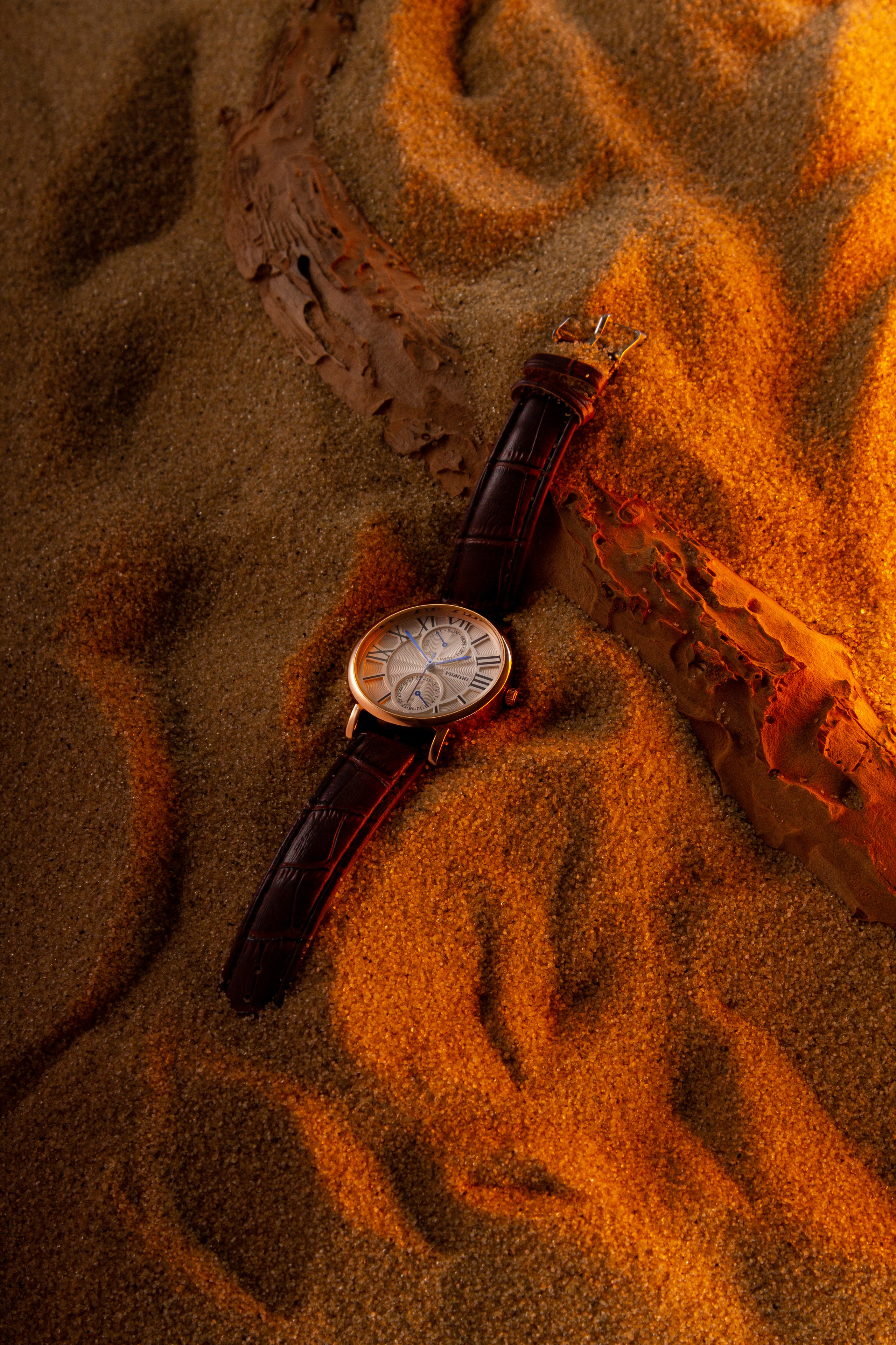 Часы на песке на закате жаркого дня 