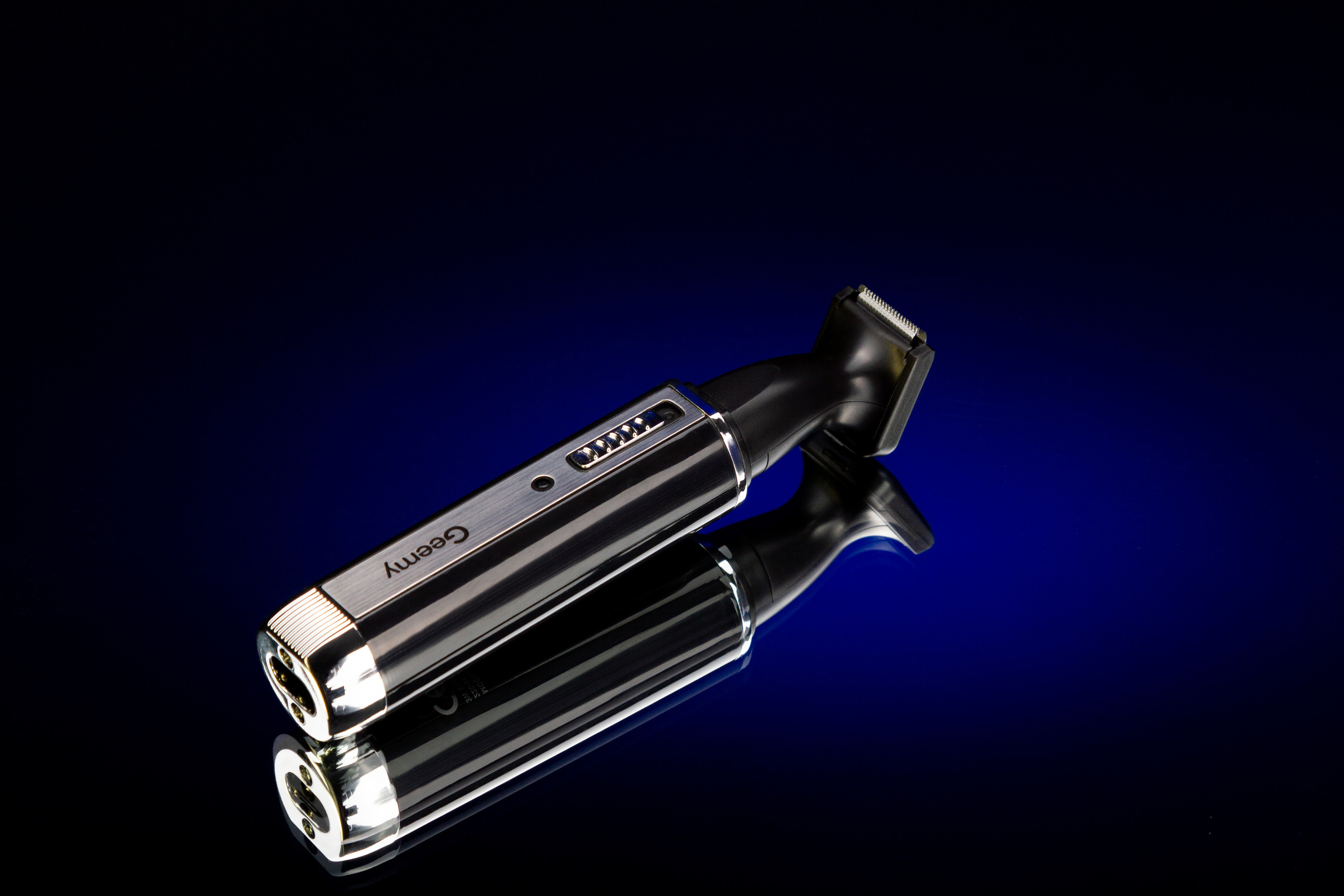 Аккумуляторная бритва на зеркальной поверхности отражается в синем пятнышке фона