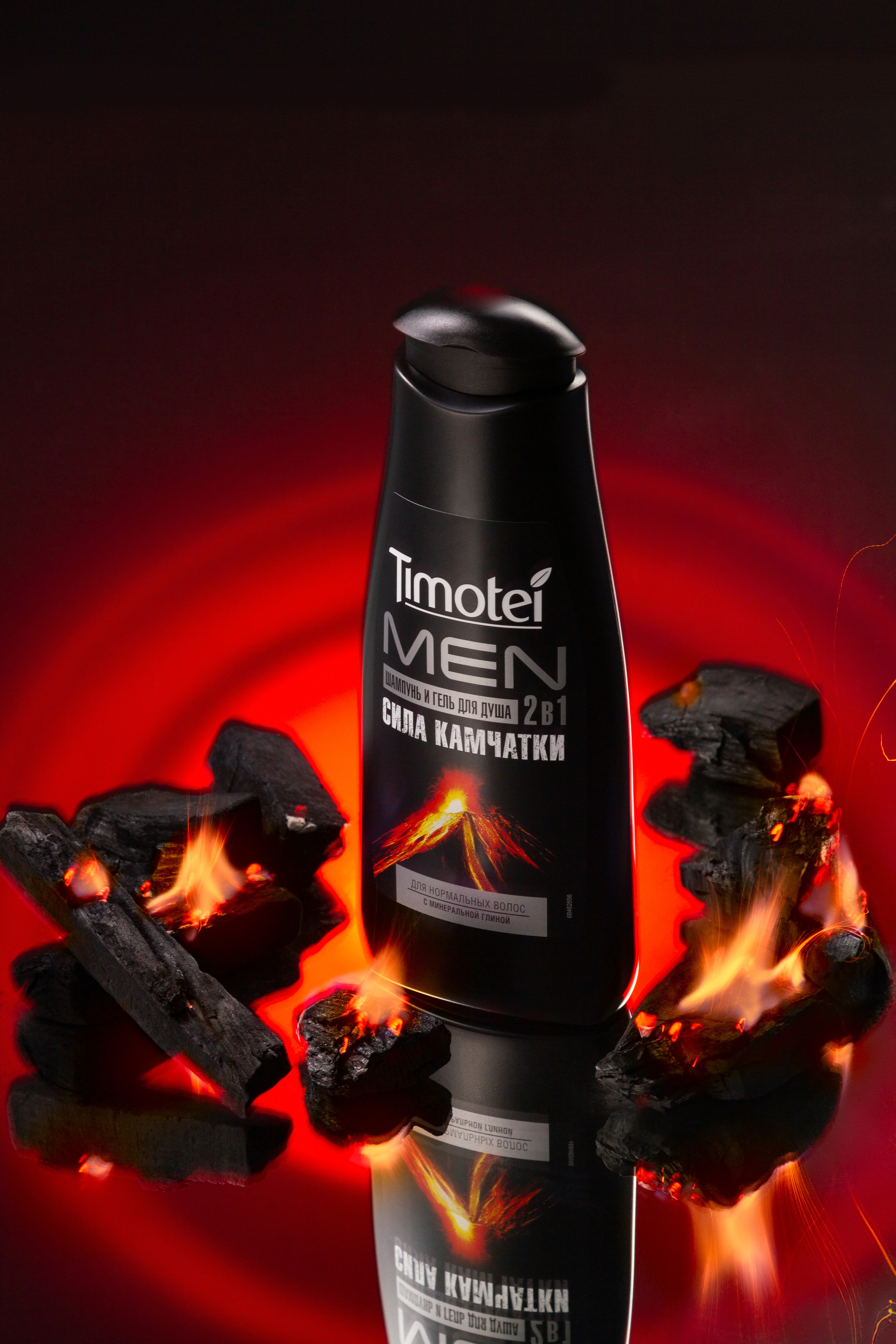 Чёрная бутылочка шампуни в огненной лаве на  зеркальной поверхности на красном фоне.