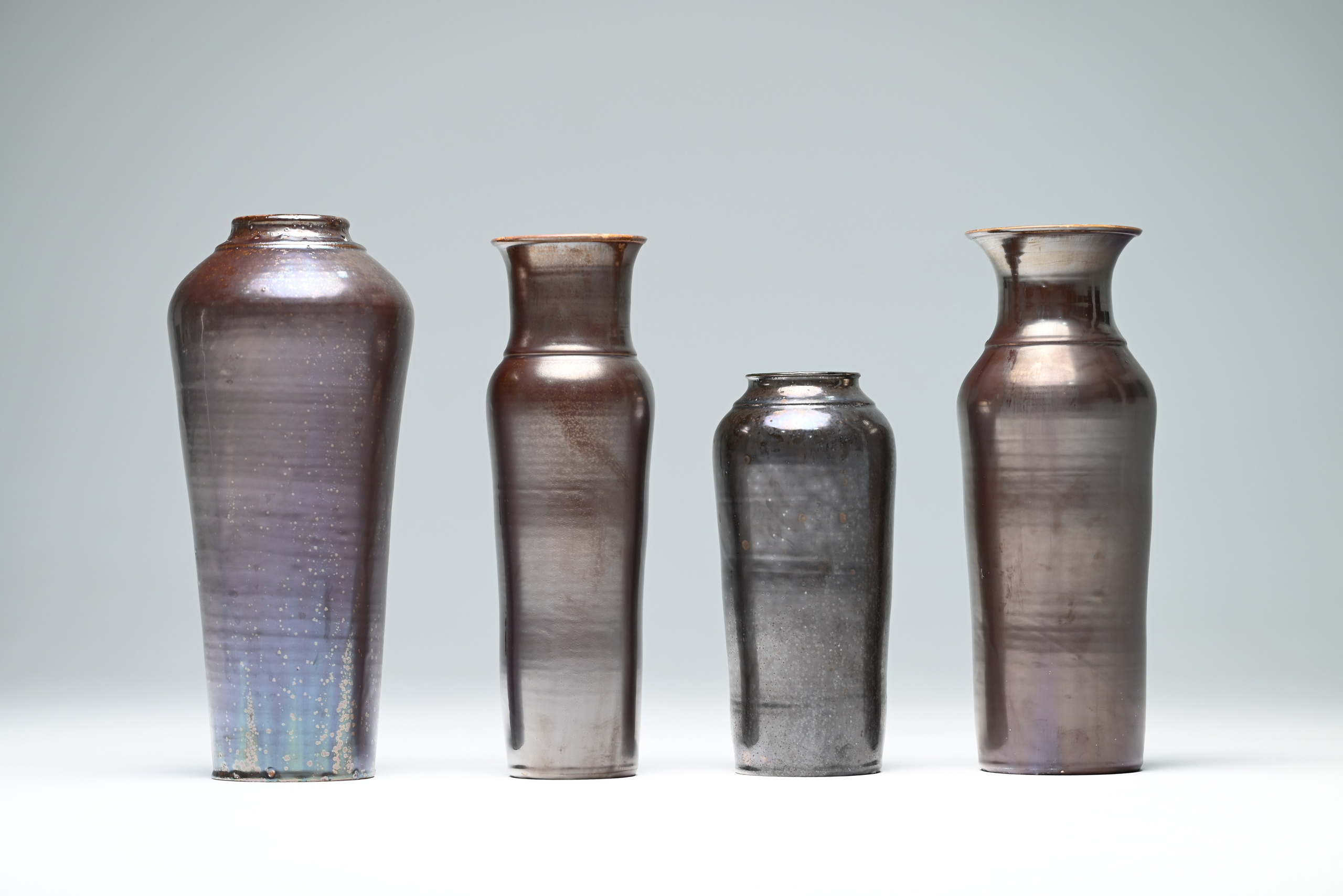 Переливы поверхности напоминают радужную бензиновую плёнку, густой дым и отблески металла.