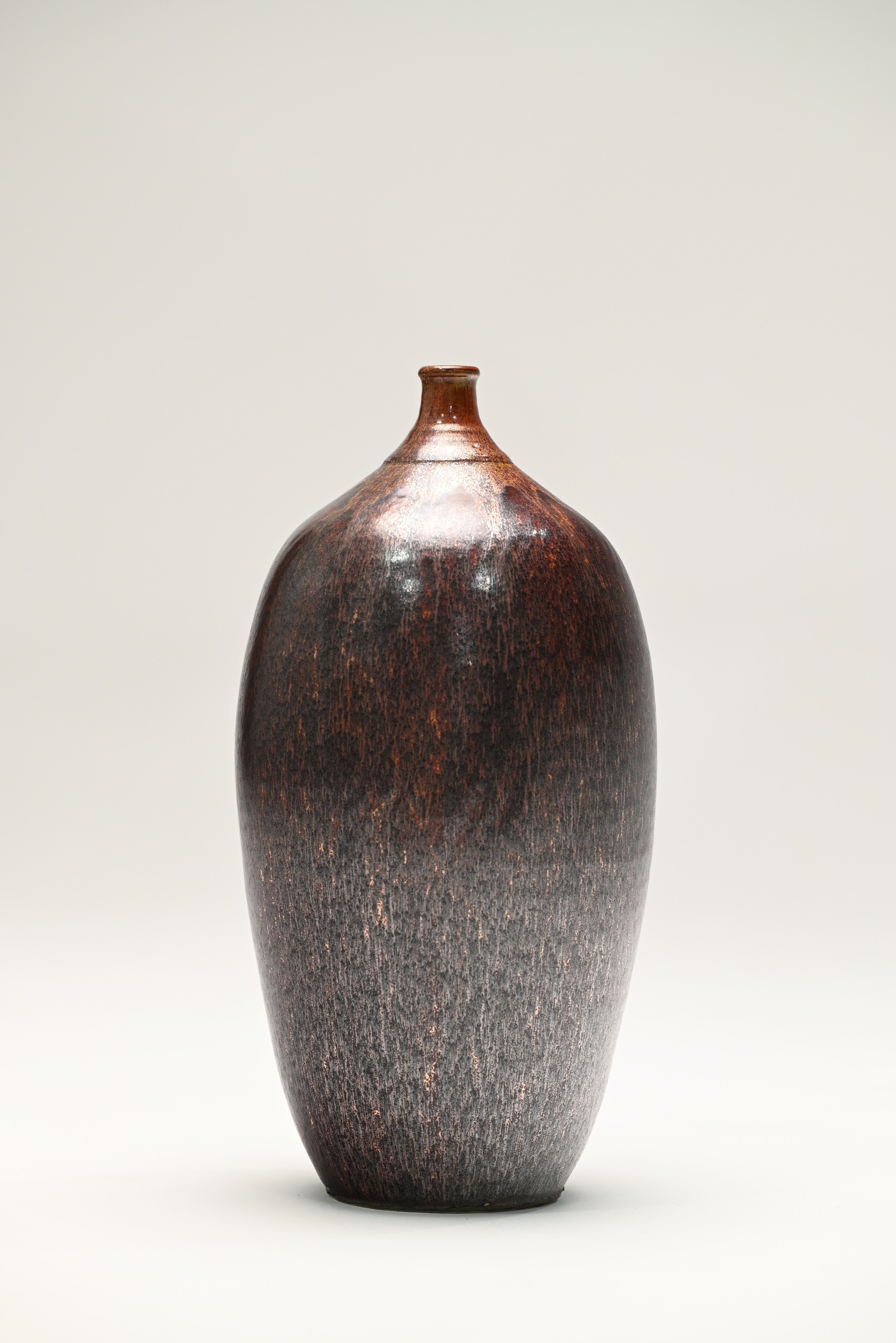 Каменная масса, глазурь.40х17 см, 2025.Форма напоминает вытянутое ядро кометы. Поверхность сосуда - глубокие переливы тёмно-коричневого и чёрного, прорезанные проблесками красноватого сияния, словно искры звёздной пыли. от лат. tenebris - «тьма»