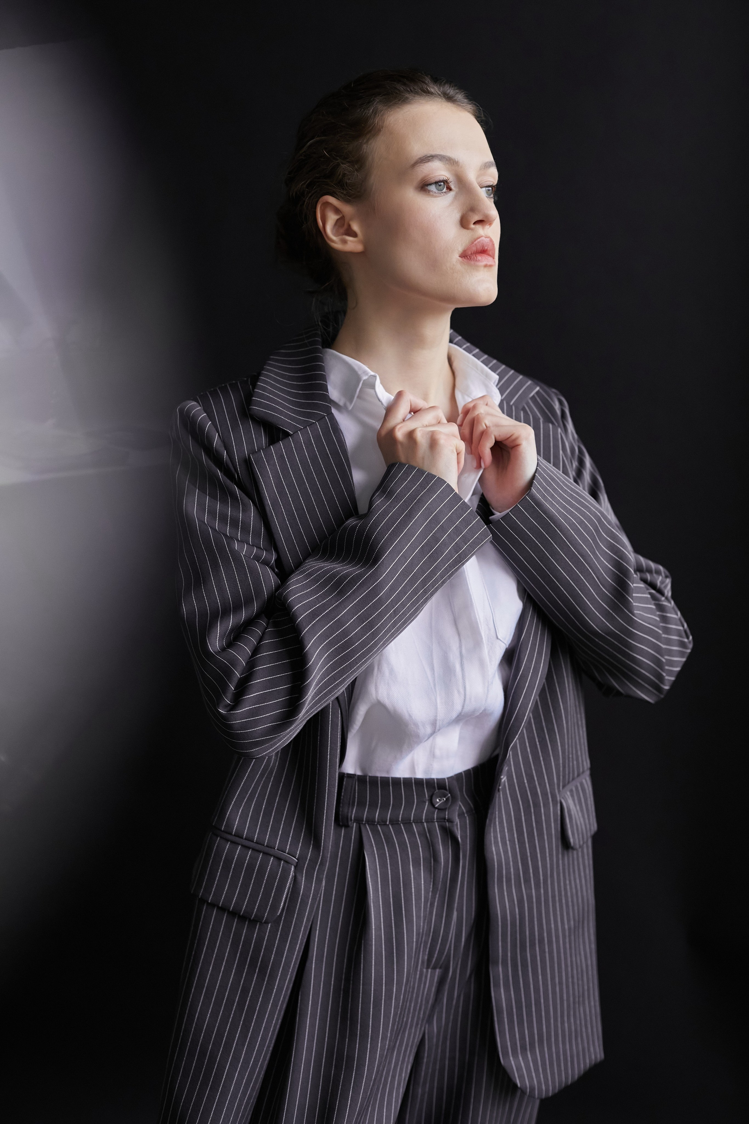 Фотограф в Москве. Студия. Студийный портрет. Девушка в пиджаке. Девушка на стуле на черном фоне. Красивая девушка в мужском костюме. Женский портрет.